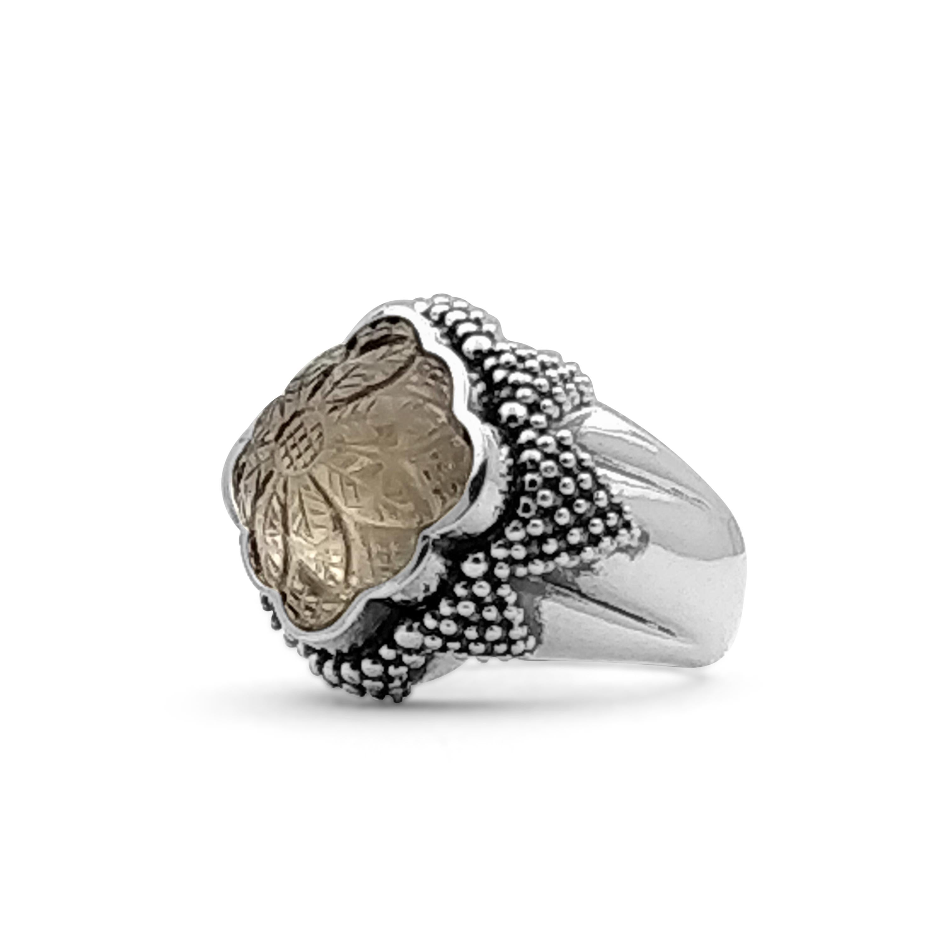 • Stephen Dweck Carventurous Collection  
• 925 Sterling Silver
• 1.25” X 0.92”

Indulge in the captivating allure of this Carved Smoky Quartz Carving Over Rhodium Coated Ring, a true masterpiece of fine craftsmanship and timeless design. Expertly
