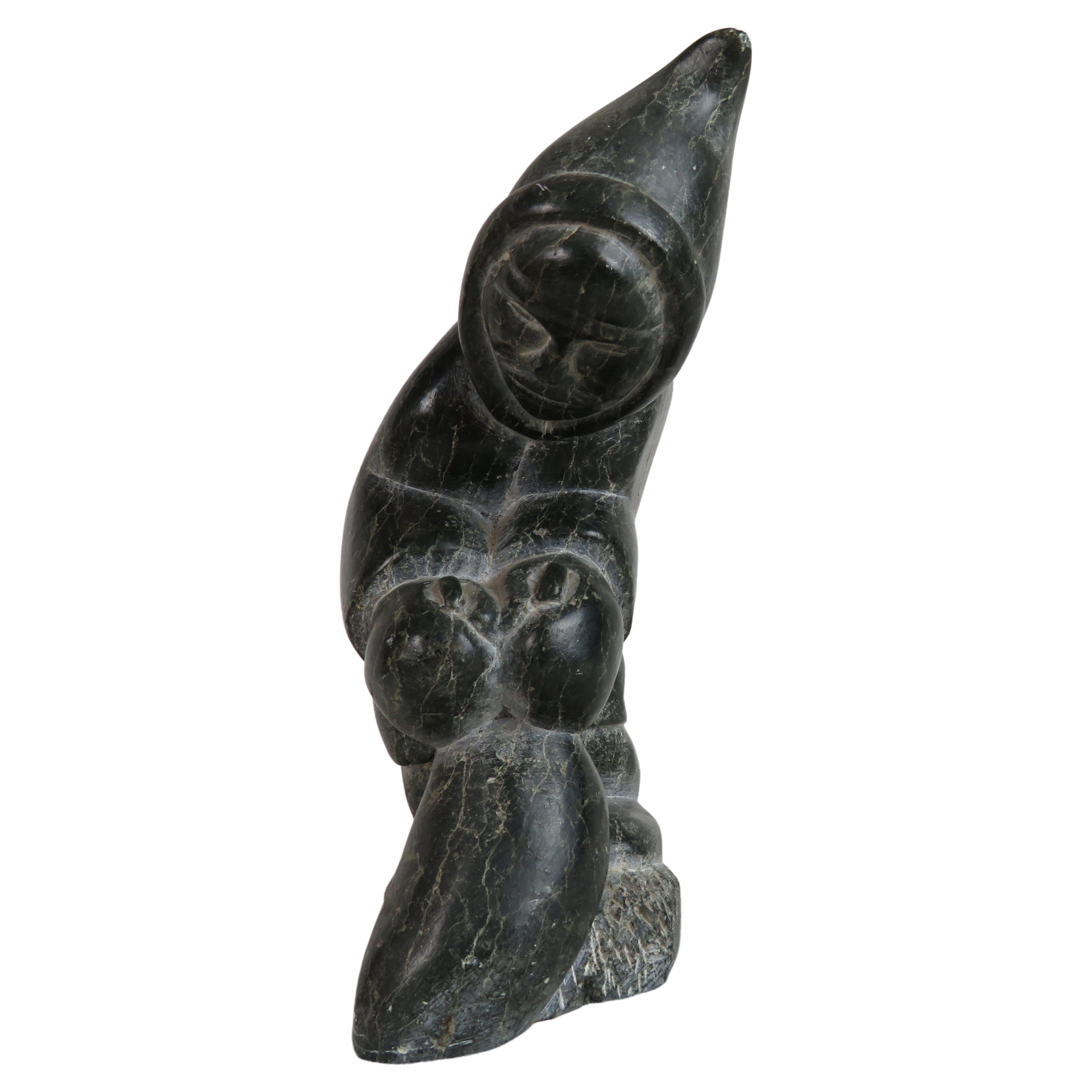 Carved Soapstone Sculpture of an Inuit Leaning Forward, Holding Bag at Feet
