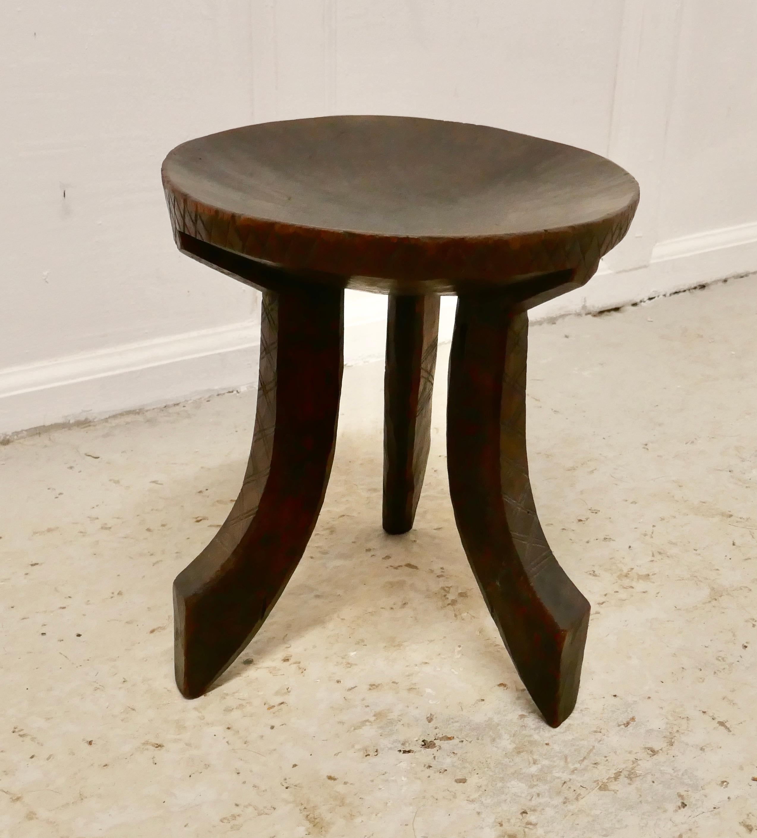 Carved solid wood African 3-legged stool

This lovely piece has been very skilfully carved out of one piece of wood, it has handsome dished seat, with 3 attractively shaped legs with decorative carving
The stool is 13” high and 12” in