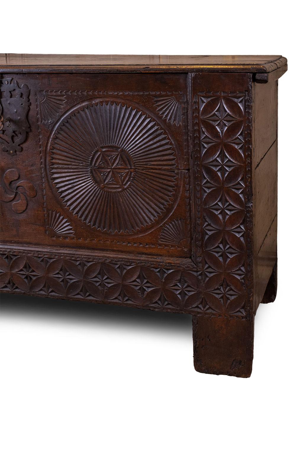 Carved Spanish chest, or coffer (or trunk), from Northern Spain. This late 18th century chest is decorated with geometric carvings and punch pattern designs, featuring a beautiful dark, rich patina and mortise and Tenon construction. Its original