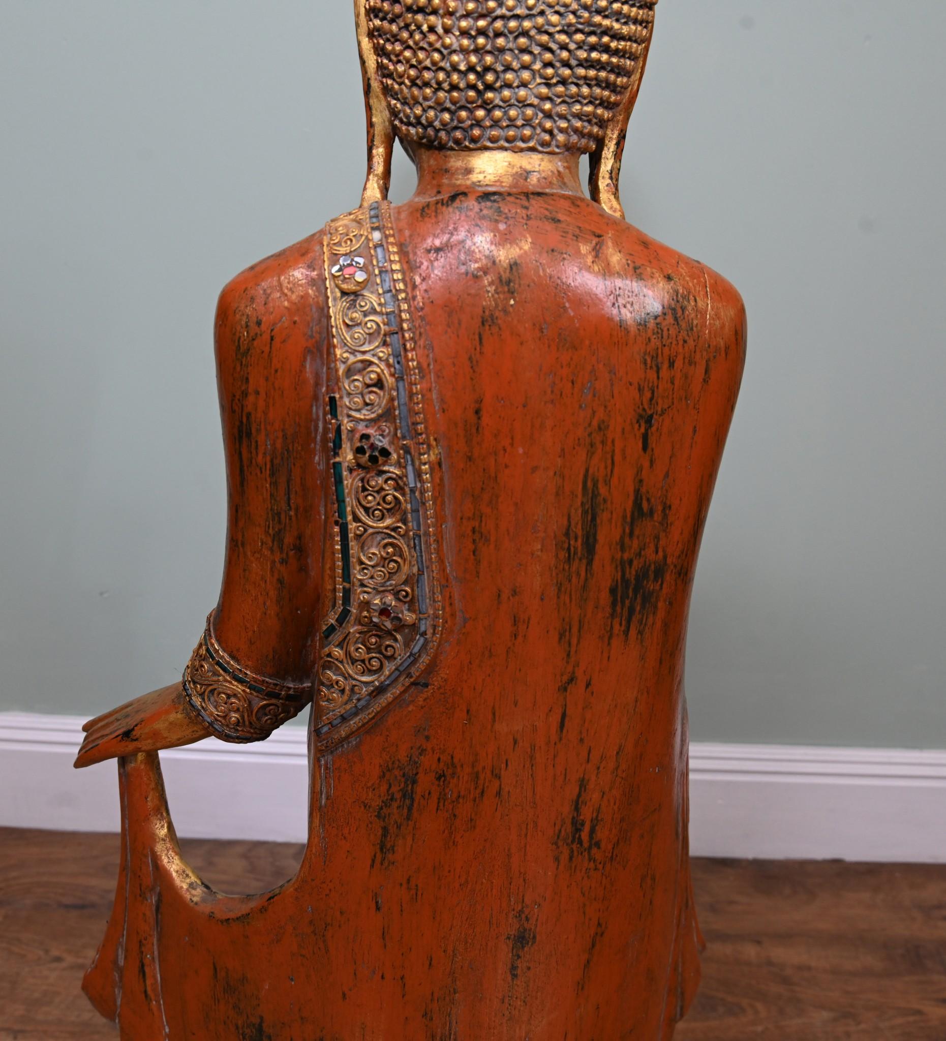 Impressive sized standing carved wood standing Thai buddha
Good size at four feet tall - 122 CM
Will add calm and serenity to any interior
The sash and hems of the buddhas tunic has been highlighted in gold paint and embellished with green, red and