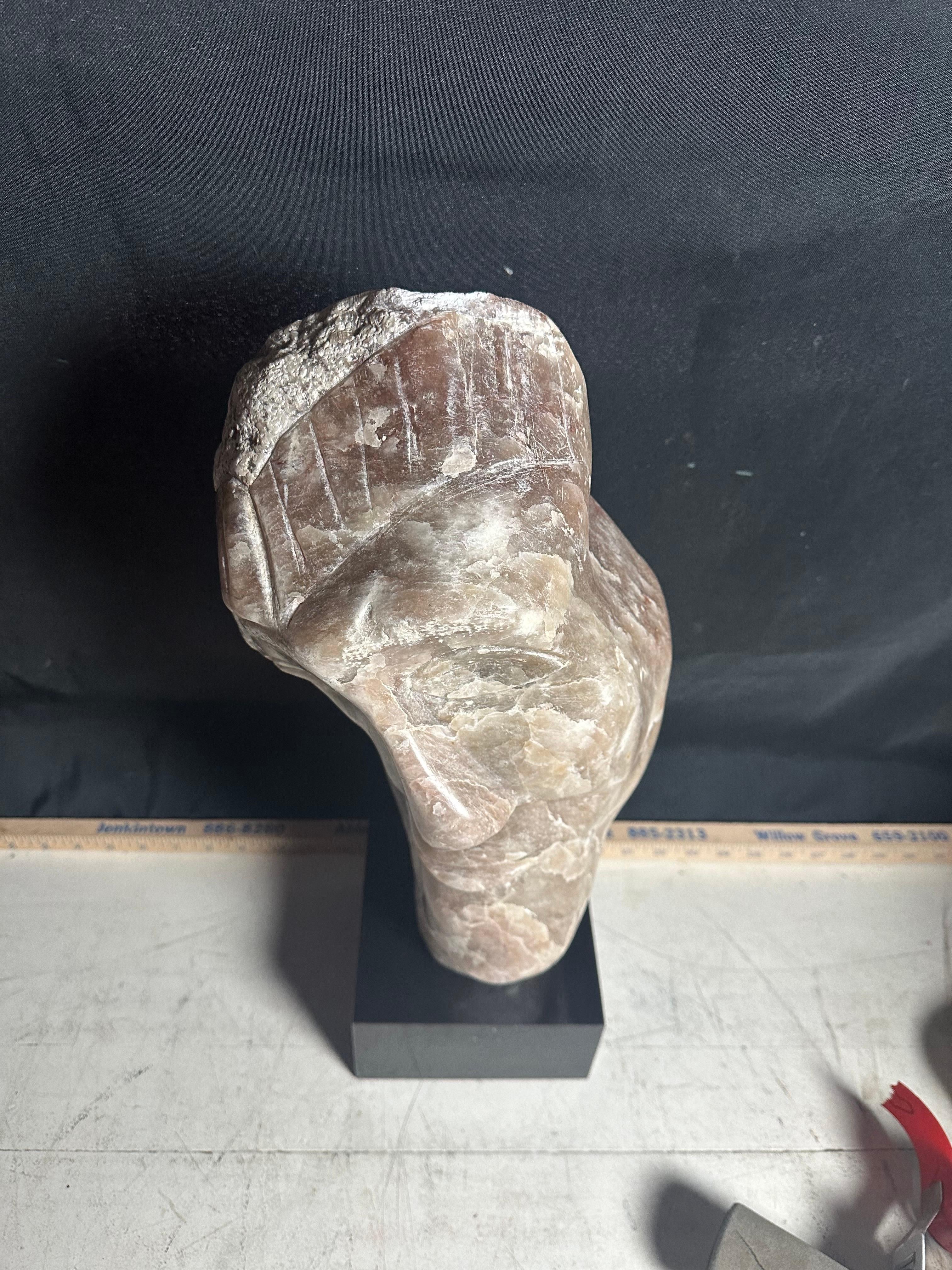 A stunning master stone carving of elongated bust over black cubed base attributed to Leon Saulter circa 1970 standing 20” tall with a width of 8” and depth of 6”. 
In fabulous condition having been carefully maintained away from sunlight. 