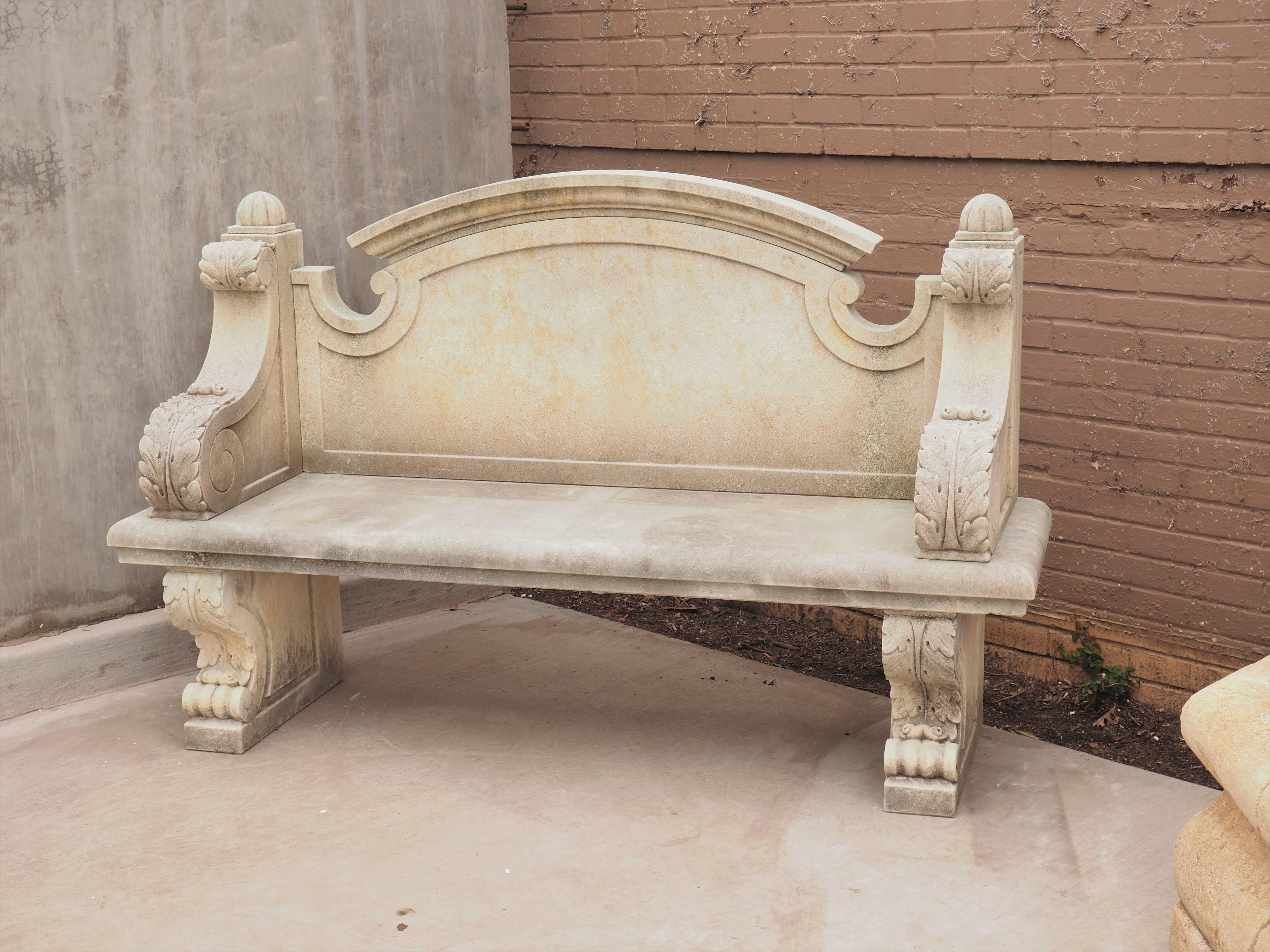 Hand-carved in Italy from six pieces of limestone, this garden bench has a shaped arched backrest and acanthus sides. The bottom of the arch of the backrest has been incised with C-scrolled edges. A thick molding follows the edges on all sides,