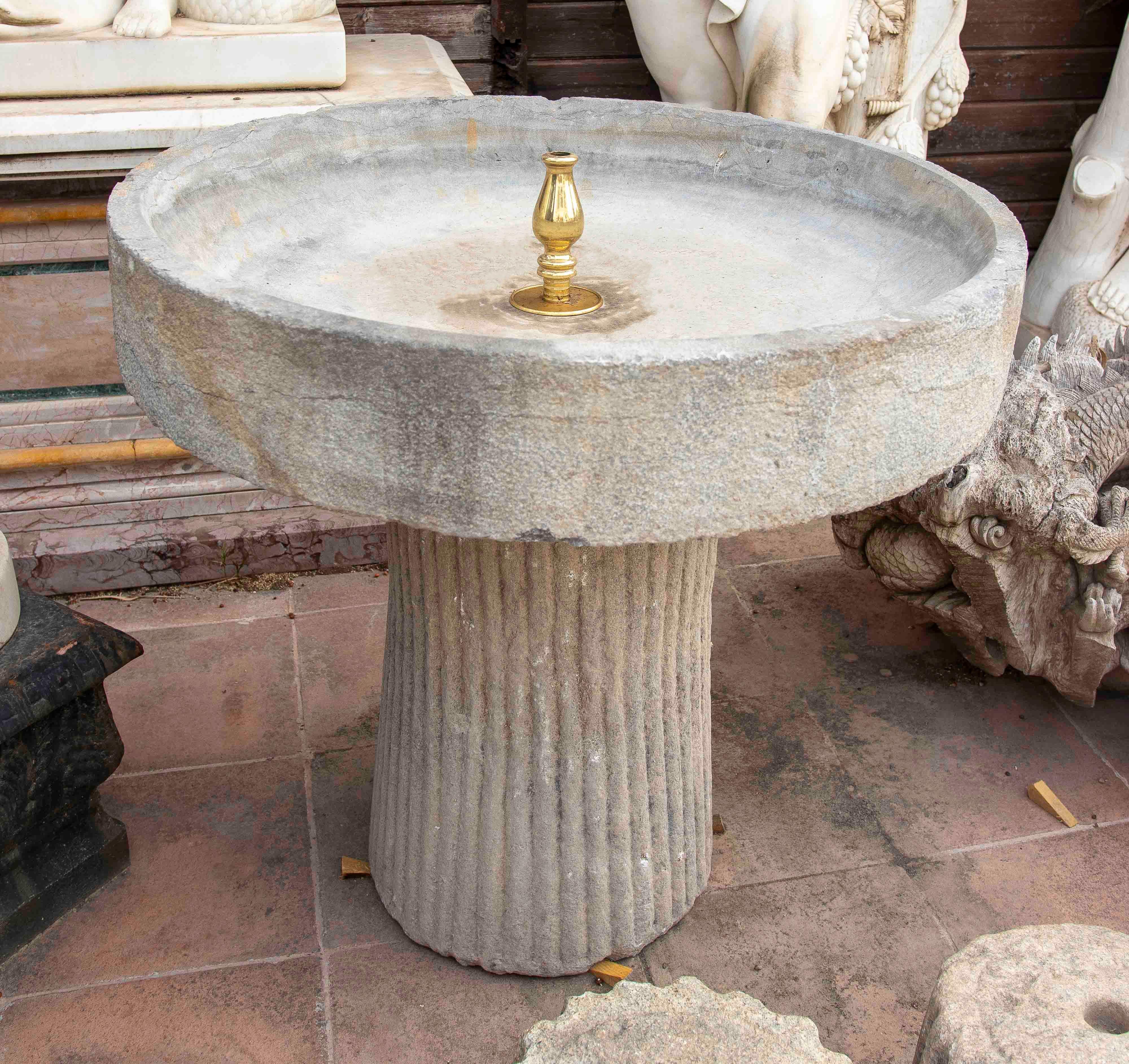 Questa fontana da giardino in pietra naturale è un pezzo elegante e funzionale che aggiunge carattere e distinzione a qualsiasi spazio esterno. La ciotola superiore, ricavata da un unico pezzo di pietra, presenta un bordo arrotondato con finitura