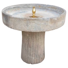 Fontana da giardino in pietra intagliata con piedistallo scanalato e terminale in ottone