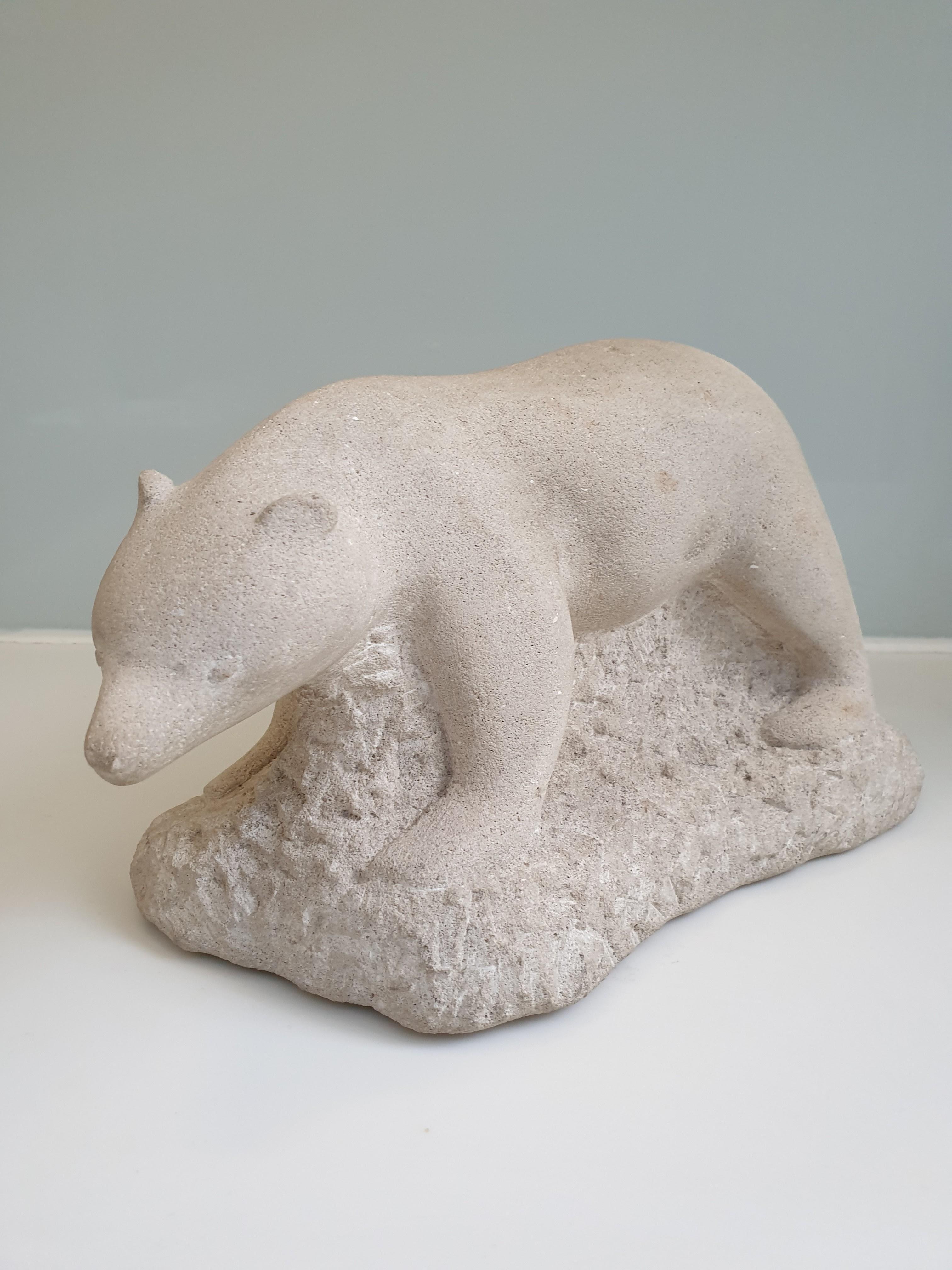 This beautiful polar bear sculpture in stone, has a whimsical quality to it. The bear is carved beautifully and its face has a sweet expression, it is possibly a polar bear cub. It is rare to see an artist, P Klinck, who can successfully represent