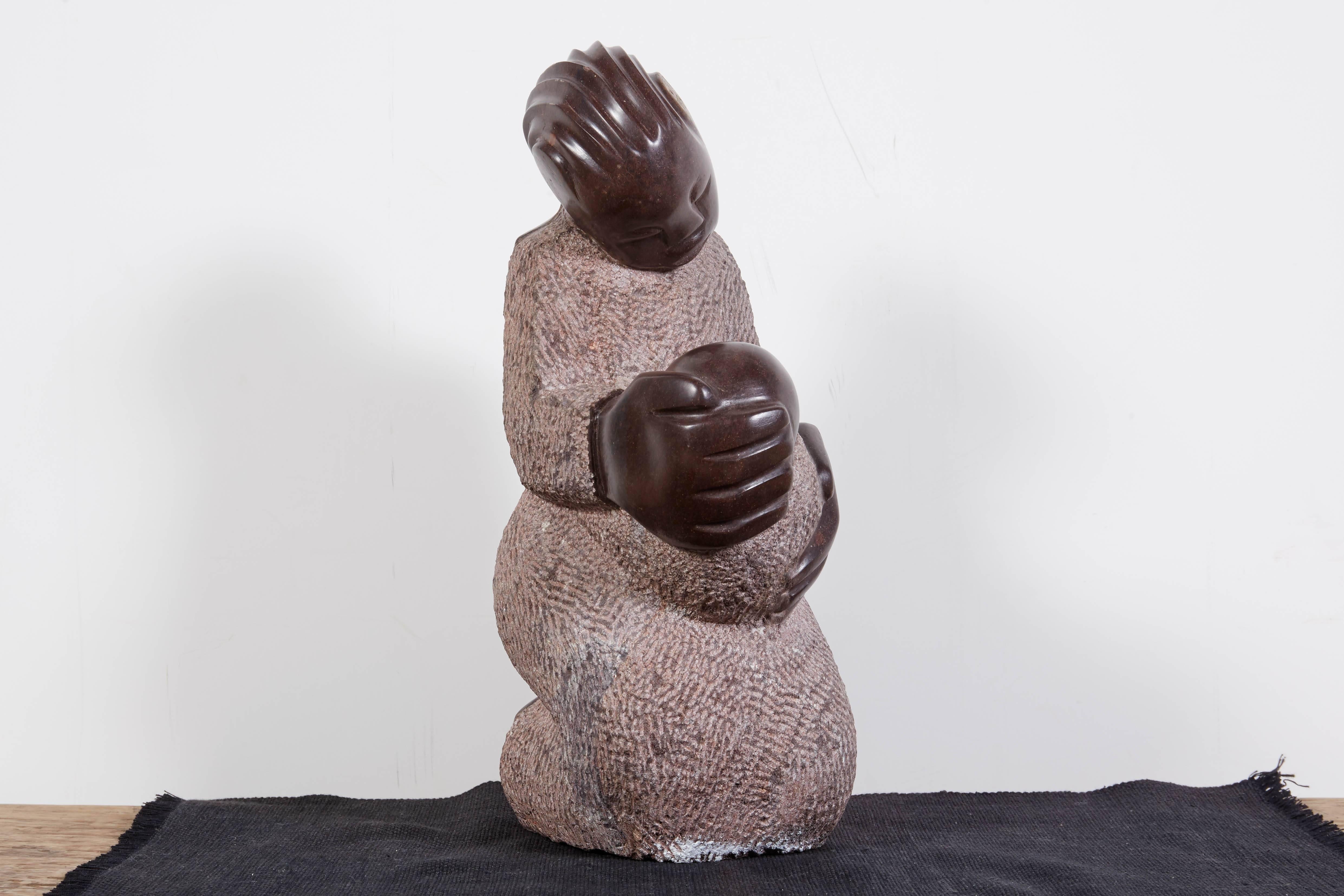 Eine wunderschön geschnitzte Shona-Skulptur aus Simbabwe, die eine Mutter darstellt, die ihr Kind zärtlich in den Arm nimmt. Ein einfaches und bewegendes Werk des Künstlers Tmuk. 
BH113.