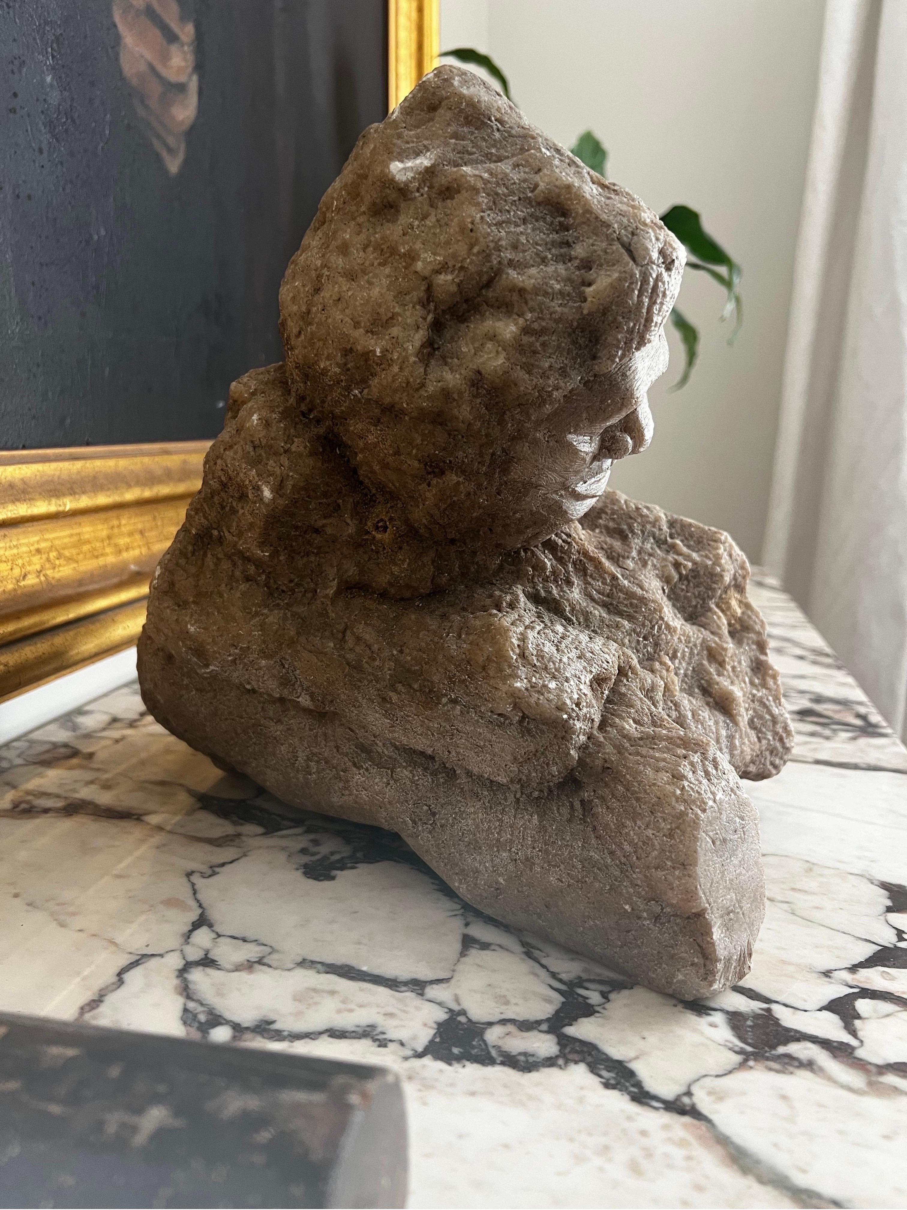 Pieza maciza de piedra tallada a mano con una cara y que aparece apoyada en una rama. 

Pieza única para mesa de centro, aparador o podría sobrevivir en un jardín.  

