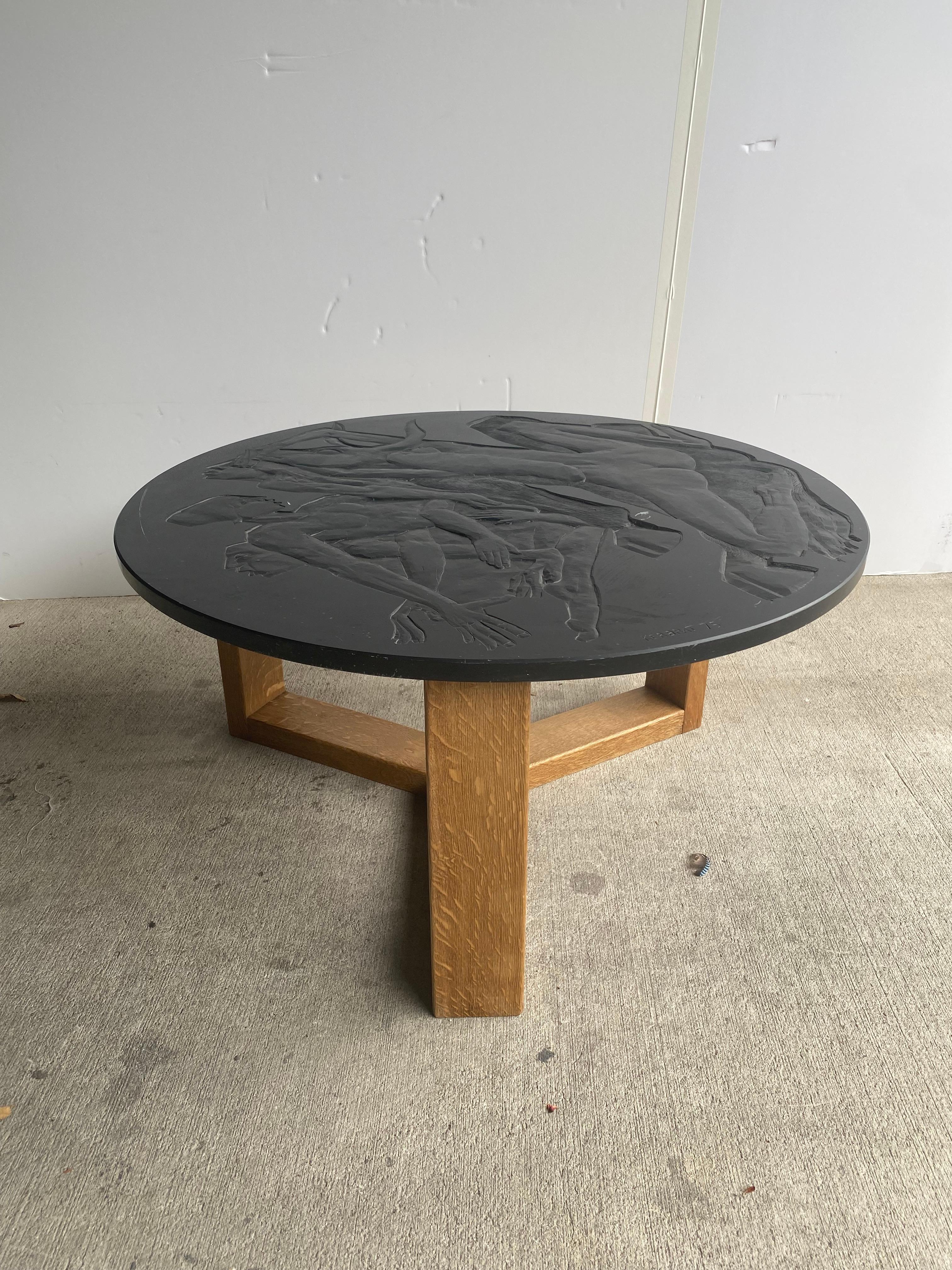 A piece of art as much as it is a piece of fine furniture. Oak based cocktail table with carved black stone top by sculptor/artist Jean Kerbrat (1939-2013). Kerbrat executed monumentally scaled works of carved stone, including over 50 public