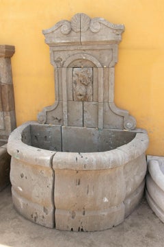 Carved Stone Wall Fountain with a Sculptural Fish and a Semicircular Basin.