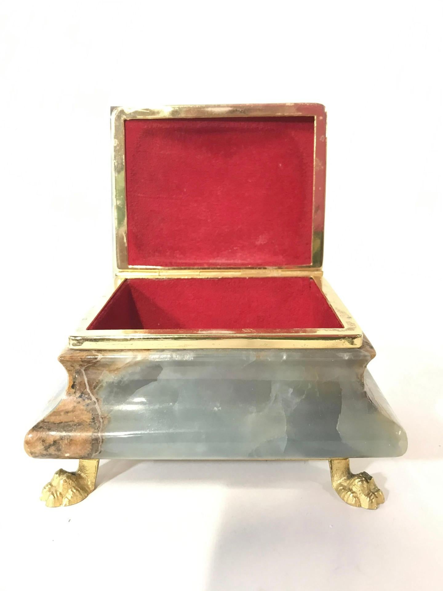 Wonderfully decorative to keep your jewelry or trinkets in. This keepsake box has gold toned claw style feet. Interior is lined with red toned fabric. Box measures approximately 5 inches long 4 inches deep 3 inches tall. 
Keepsake box, trinket box,