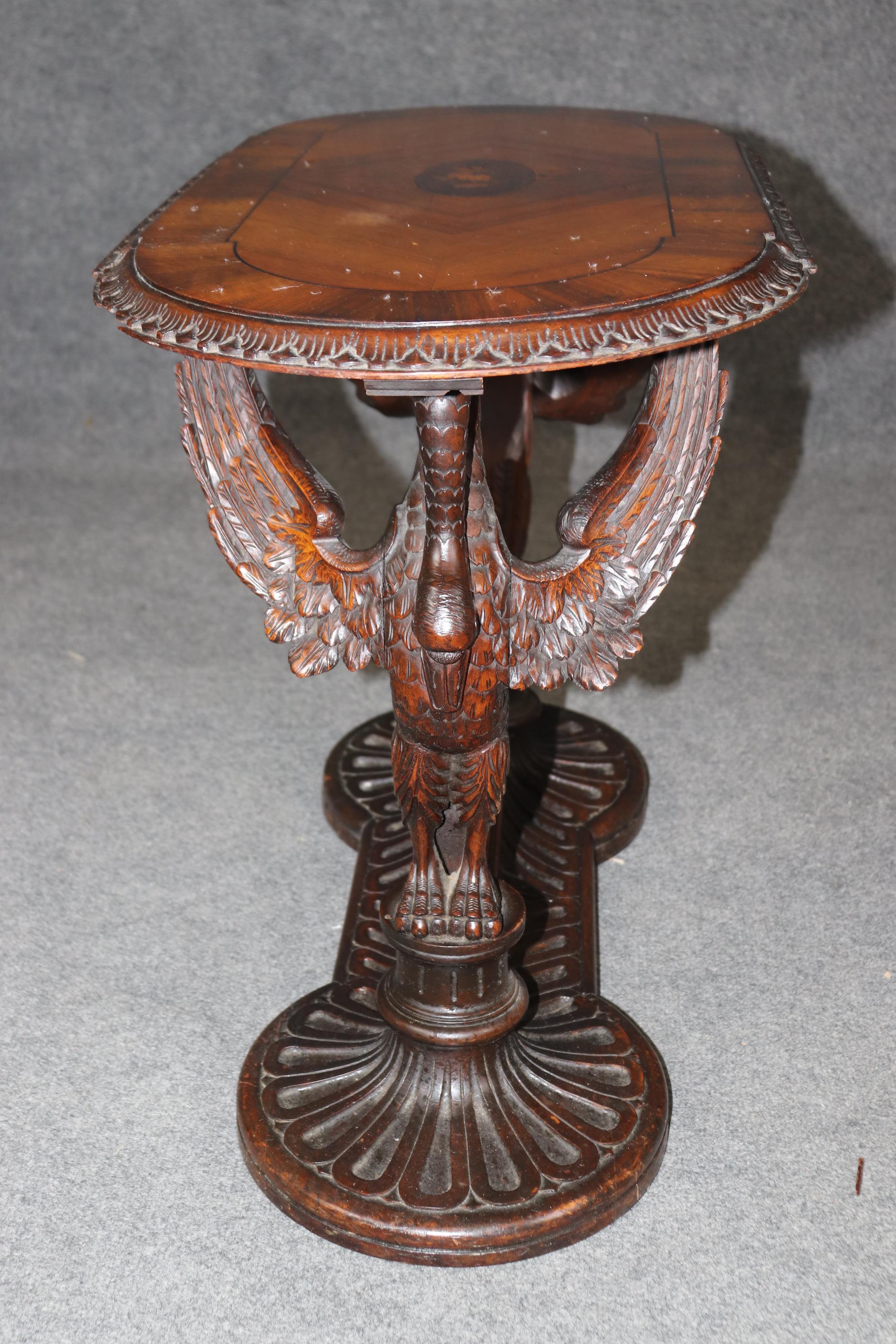 This is a carving enthusiast's delight. This gorgeous hand-carved occasional or tea table is features naturalistic carved swans and gorgeous inlay on top. The walnut table features its original finish and ill show minor signs of age and use such as