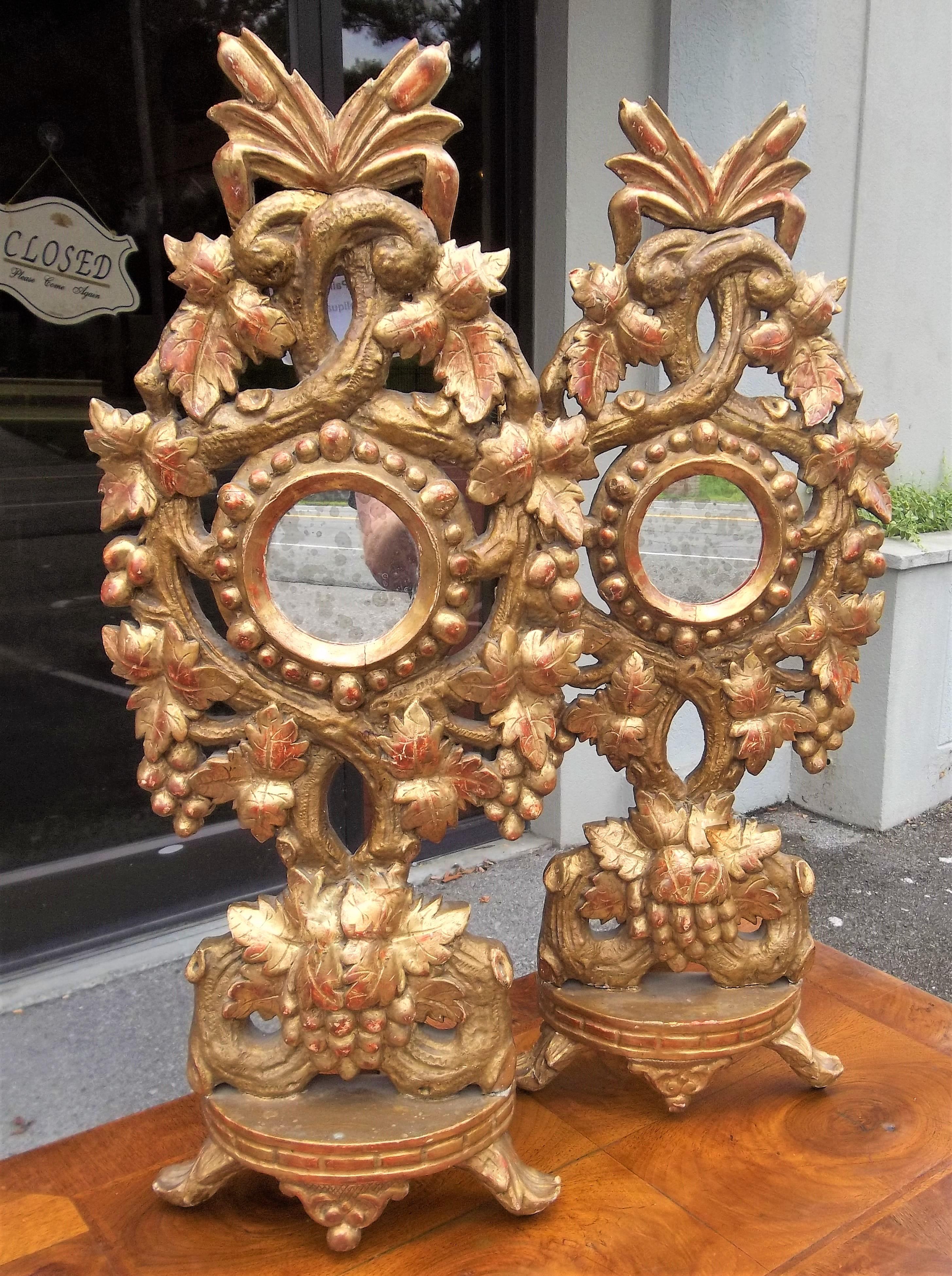 Carved gilt reliquaries now with antique mirror insets (garnitures). In full relief intertwining vine with leaves and grapes. Water and matte gilding. Very rich red bole bleeding throughout each. Late Baroque transition to Rococo influence, France