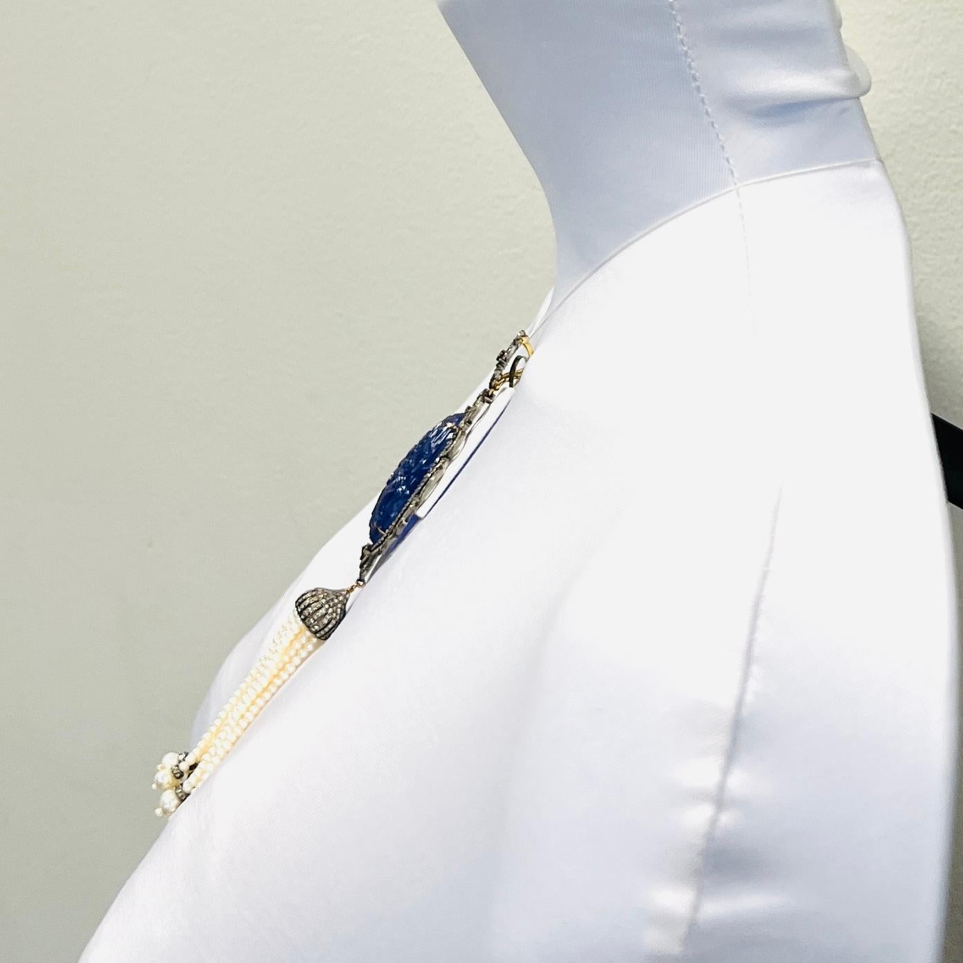 Bellissima tanzanite intagliata a forma di pera con diamanti bianchi rotondi di buona qualità e perle bianche rotonde.  Realizzato a mano in oro bianco e rodio 14k.  
