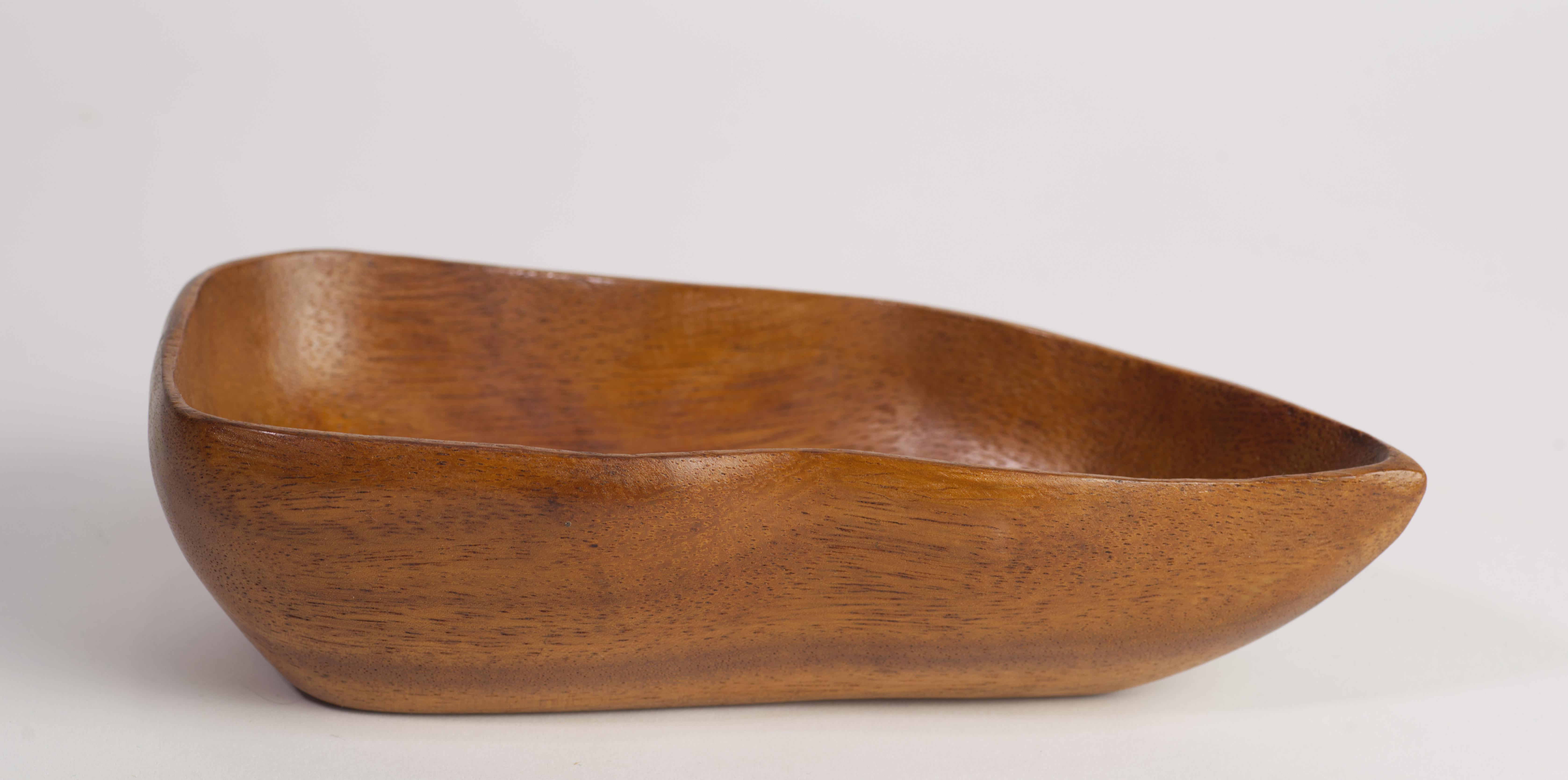  Vintage asymmetrical carved wooden bowl was hand made in Haiti from Taverneau, also known as Caribbean Walnut or False Tamarind, a durable tropical hardwood with a golden hue. It is done in style of Taverneau wood tray platters designed by Arthur
