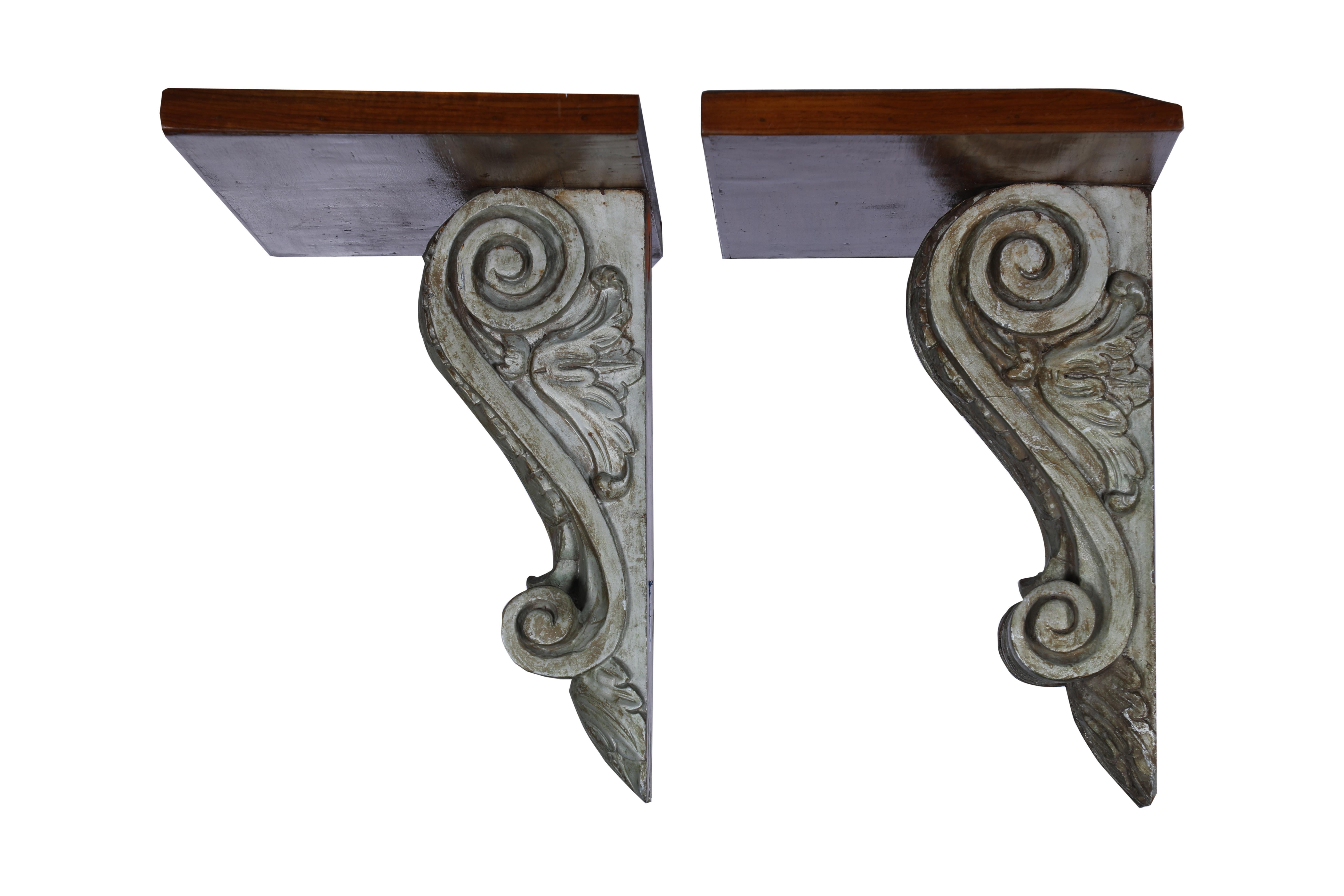 Lovely hand carved teak wall brackets with an acanthus leaf and scroll design. With the original pewter paint. The teak shelves on top have been added, circa 1940s, Colonial British. Notched on the backside for mounting.