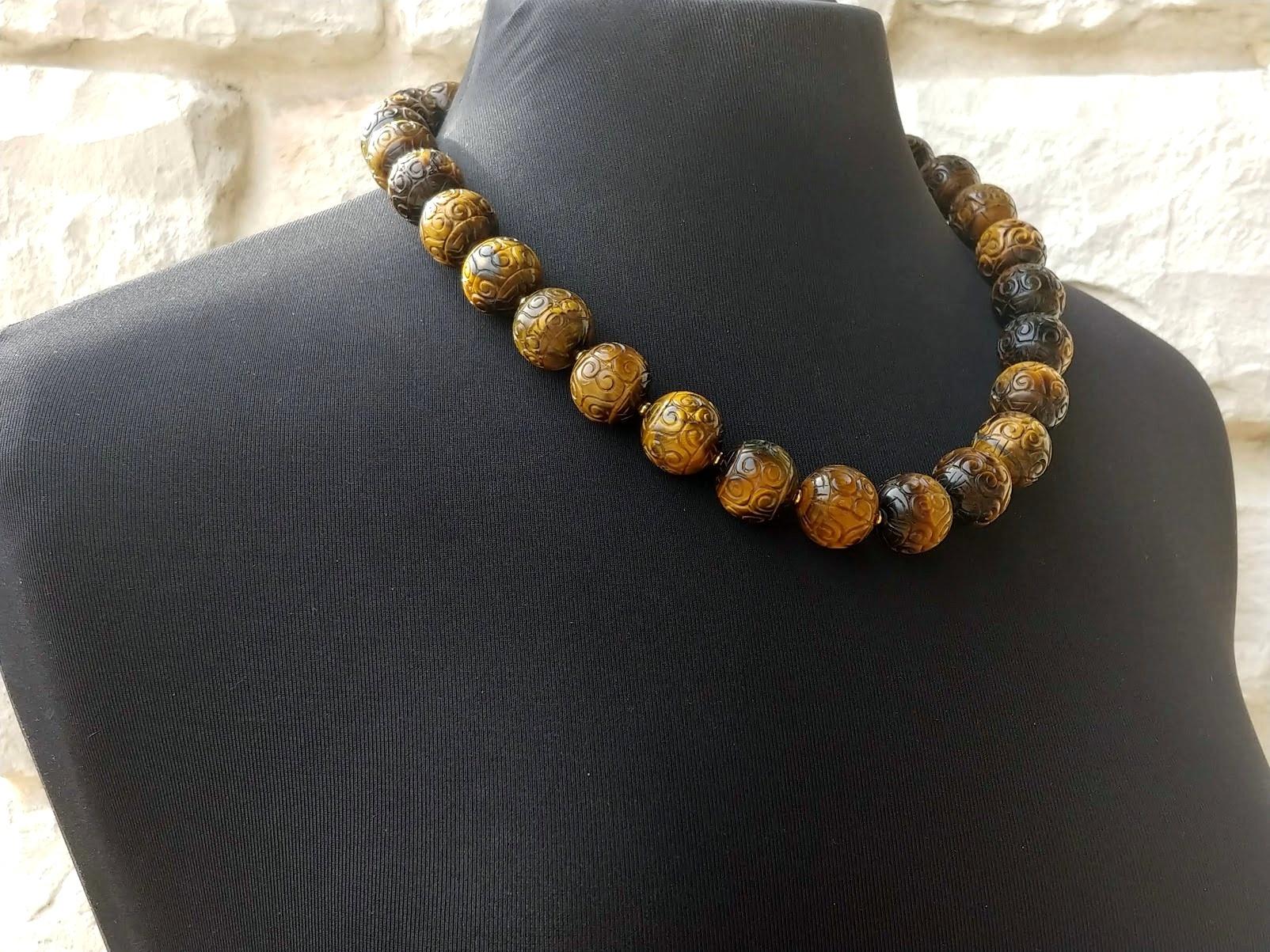 The length of the necklace is 22 inches (55.8 cm). The size of the carved round beads is 18 mm.
The tones of the beads are a wondrous golden brown, caramel gold, and silky — gorgeous warm shades.
The color is authentic and natural. No thermal or