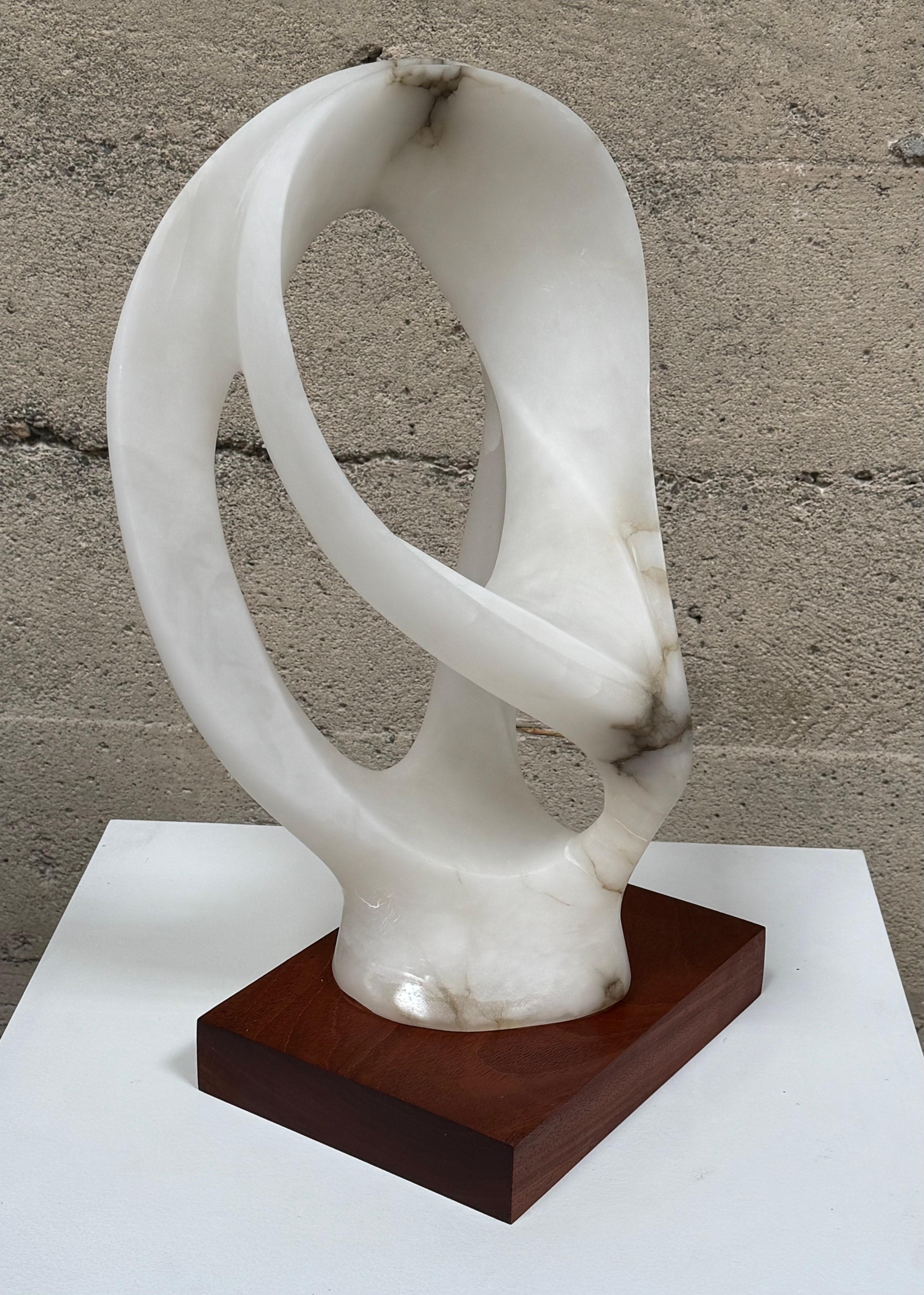 Sculpture abstraite en marbre de carrare translucide des années 1960, sculptée à la main sur un socle en bois dur. Sculpture abstraite de forme libre rappelant l'œuvre de Jean Arp. Le marbre est tel qu'il laisse passer la lumière, créant ainsi un