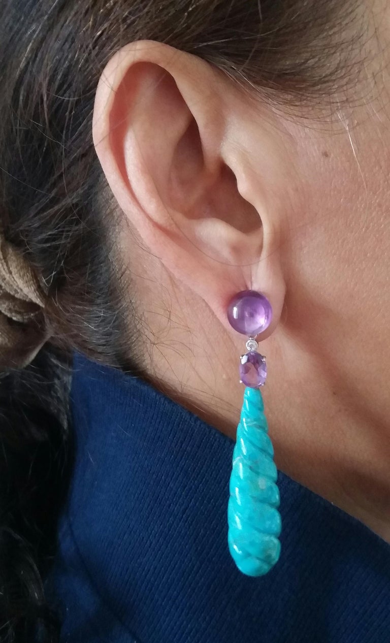 In these earrings we have the upper part consisting of 2 round  amethyst buttons, then  2 oval faceted amethyst ,2 small diamonds and 2 engraved turquoise round drops measuring 12x 40 mm
In 1978 our workshop started in Italy to make simple-chic Art
