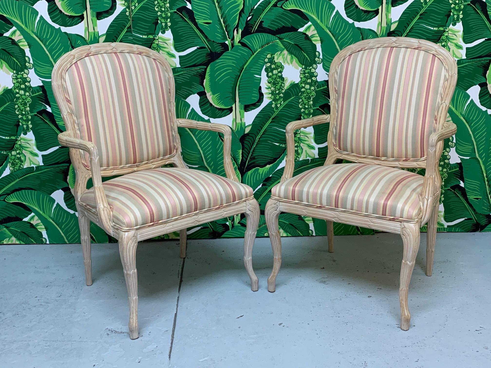 Pair of vintage faux bois twig style carved dining chairs. Upholstered in a striped pattern with frames in the classic twig style. Attributed to Century Furniture Co. This listing is for the pair. If interested in purchasing more, message us. Good