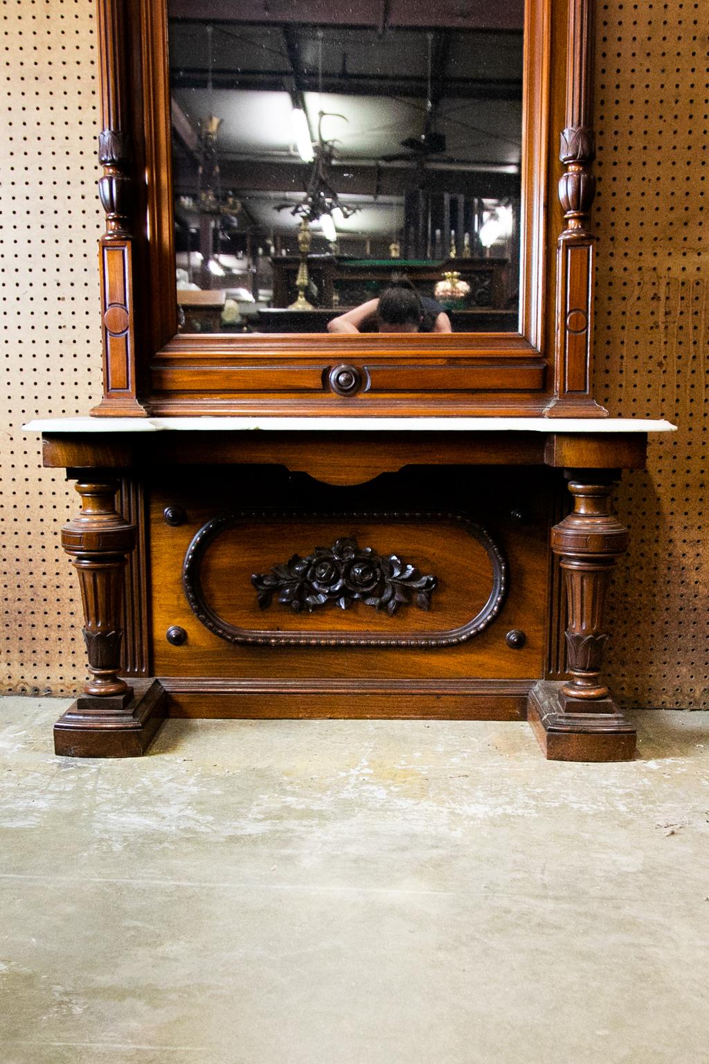 Miroir d'angle victorien anglais en noyer sculpté, avec colonnes cannelées sculptées à la main et chapiteaux corinthiens. La moulure de la crête est sculptée en volute et le cartouche central est sculpté de feuilles d'acanthe. La section inférieure