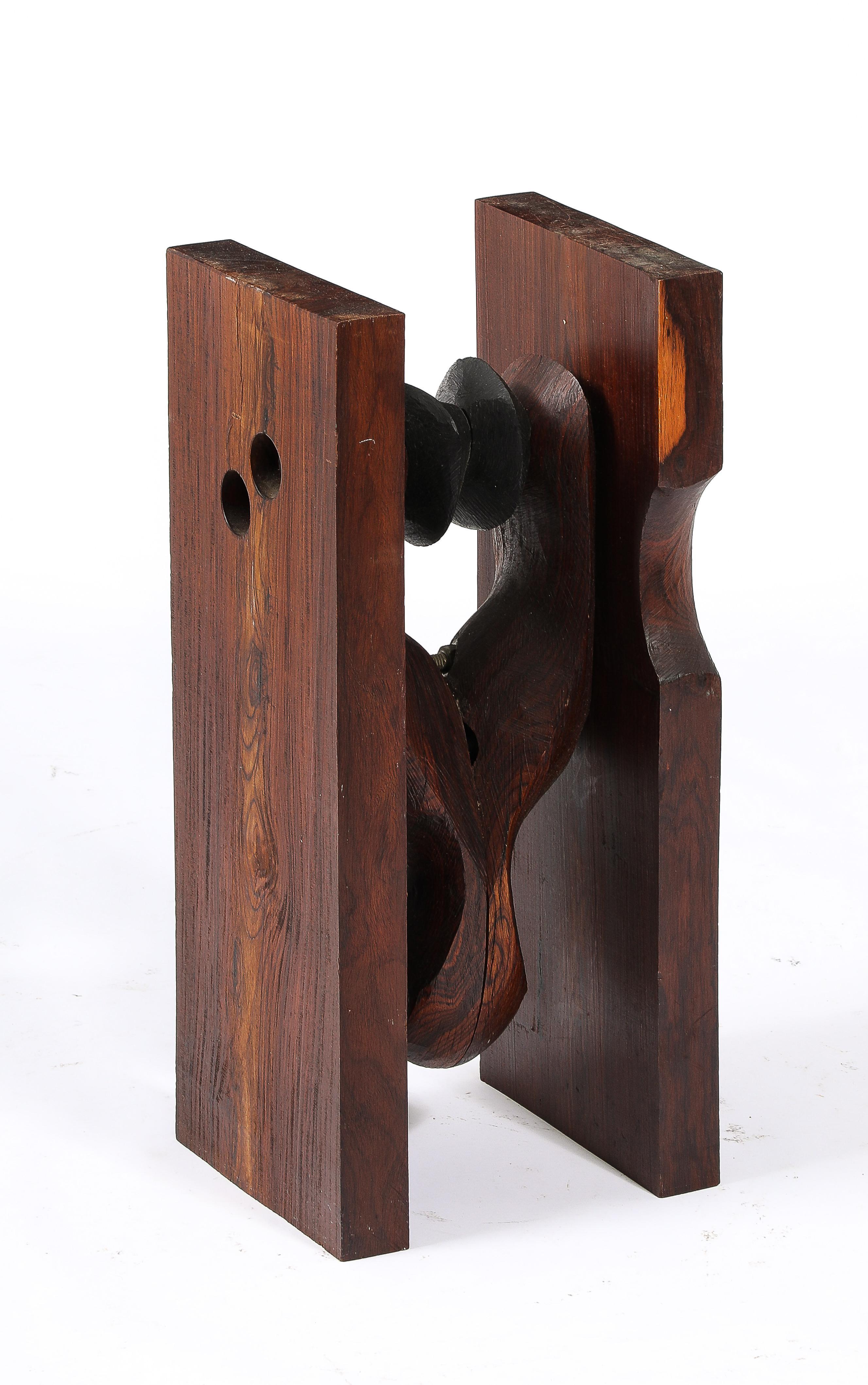 A solid carved walnut end table, the rough-hewn planks frame a stylized fist, its top is a thick cobalt blue glass