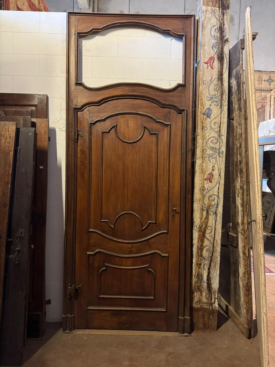 Antique walnut door, carved both in the panels and in the original frame, which is tall and has space for an overdoor. A curved door with carved panels. Complete with frame and overdoor, which once held a painting. Original from the 18th century,