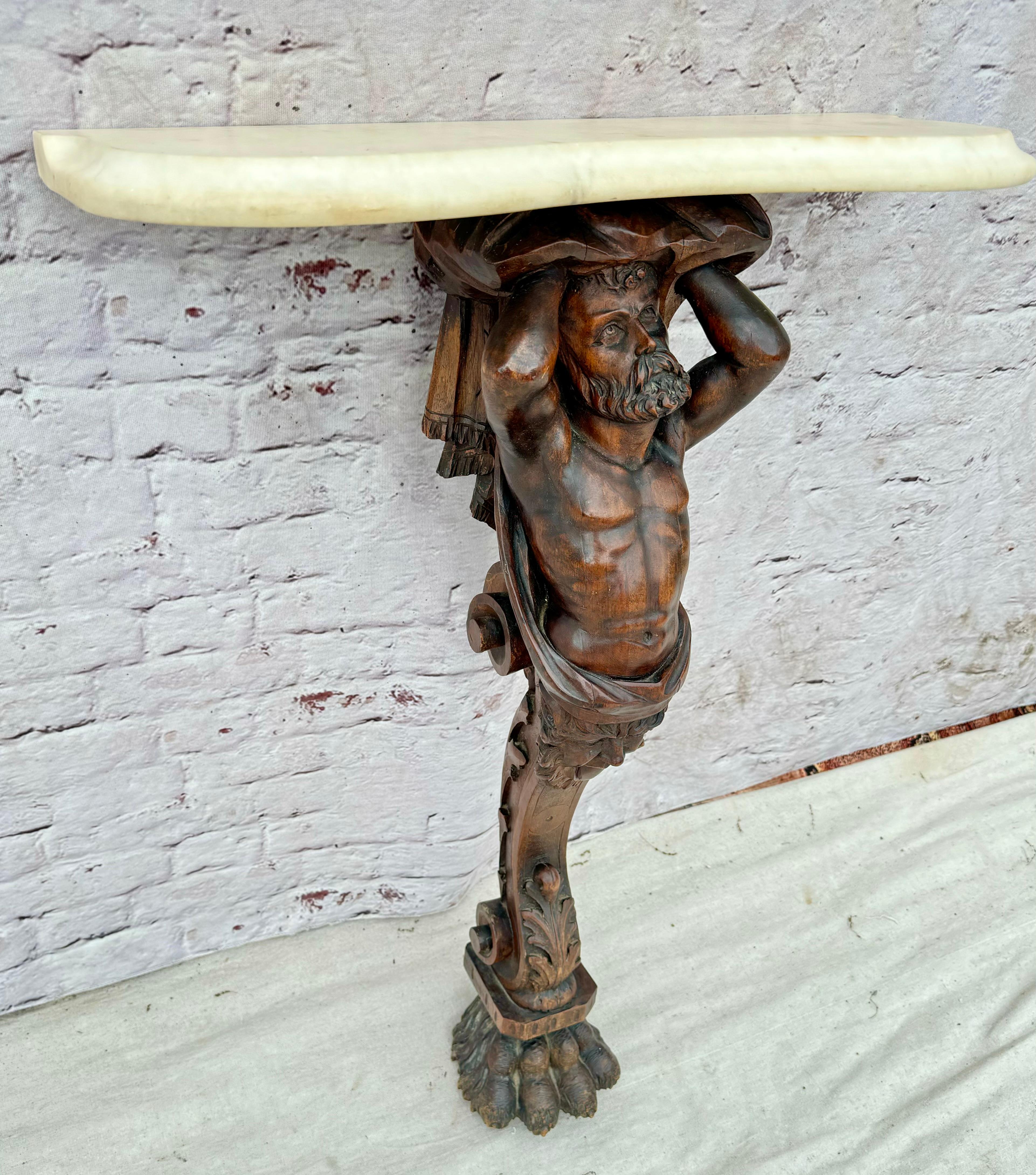 Unverwechselbare figural geschnitzte Nussbaumfigur aus dem 19. Jahrhundert, die einen Marmoraufsatz hält. Die bärtige Figur hält mit erhobenen Armen eine Marmorplatte als Konsolentisch. Die Schnitzerei ist aus einem Stück gefertigt und zeigt den