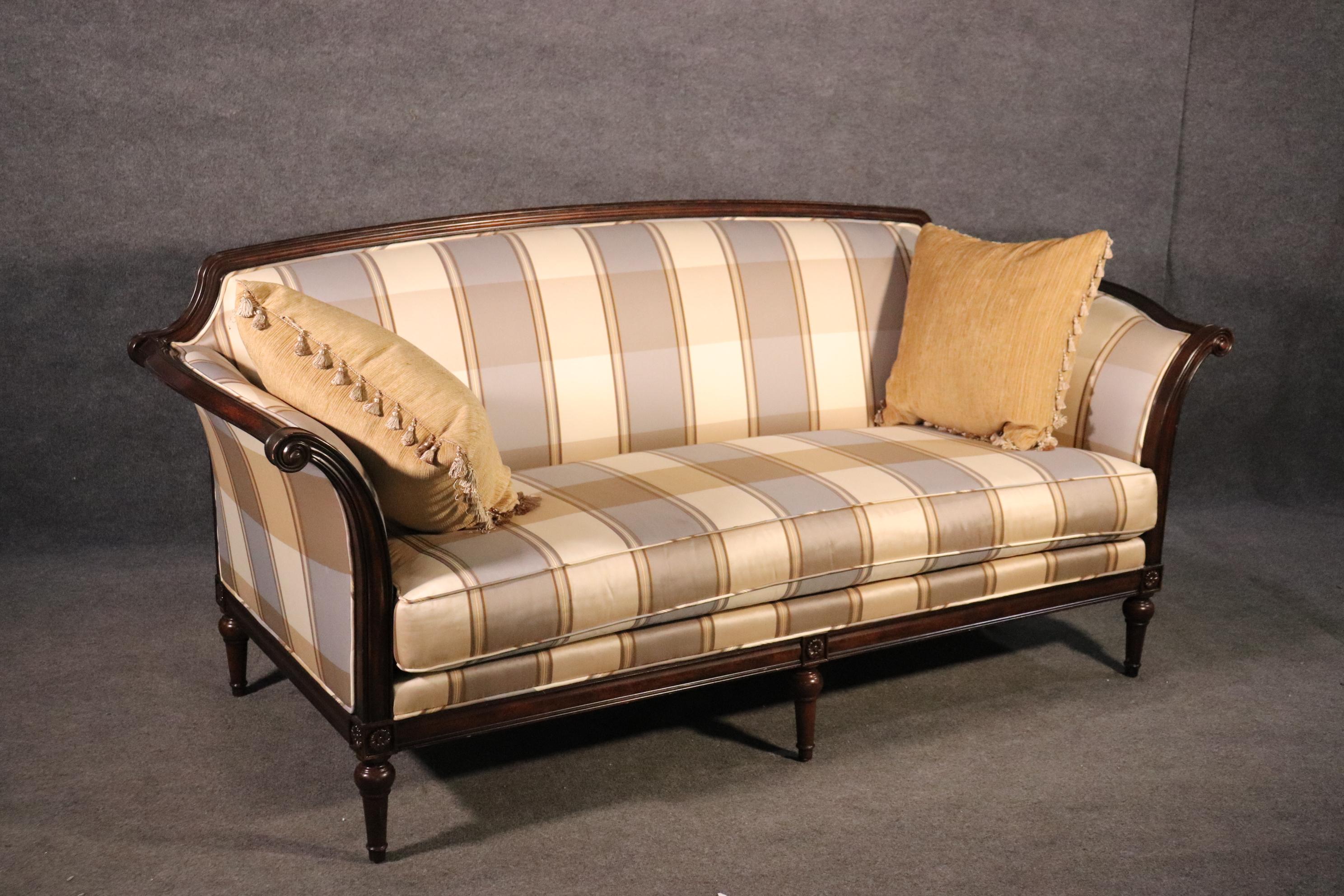 This is a beautiful sofa with gorgeous upholstery and a great carved walnut frame in the Louis XVI style. The sofa is American-made and of the highest quality. The upholstery is clean and while it is used, is not very worn or stained at all. The