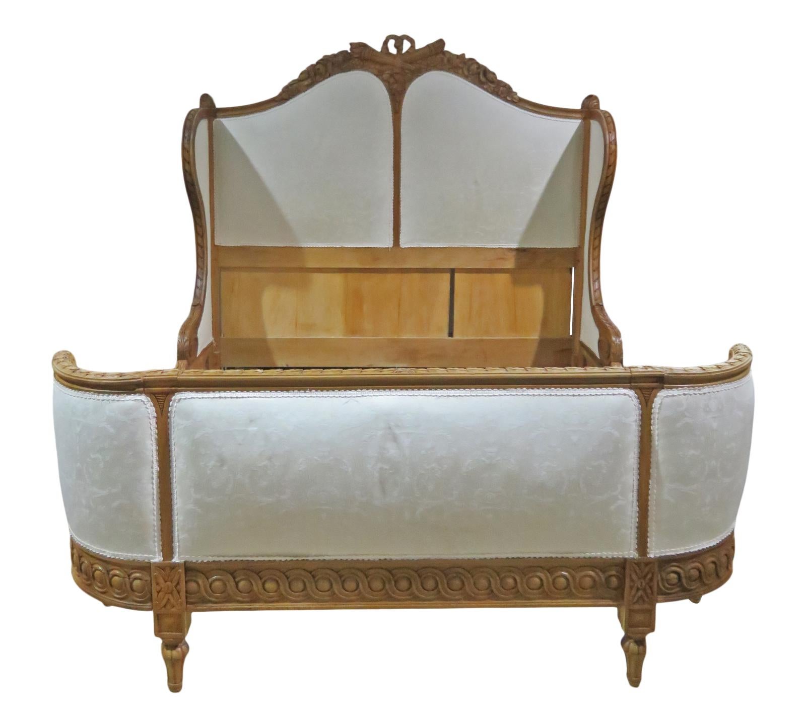 Carved wood frame. Upholstered headboard and footboard. With rails. Measures: 62 3/4