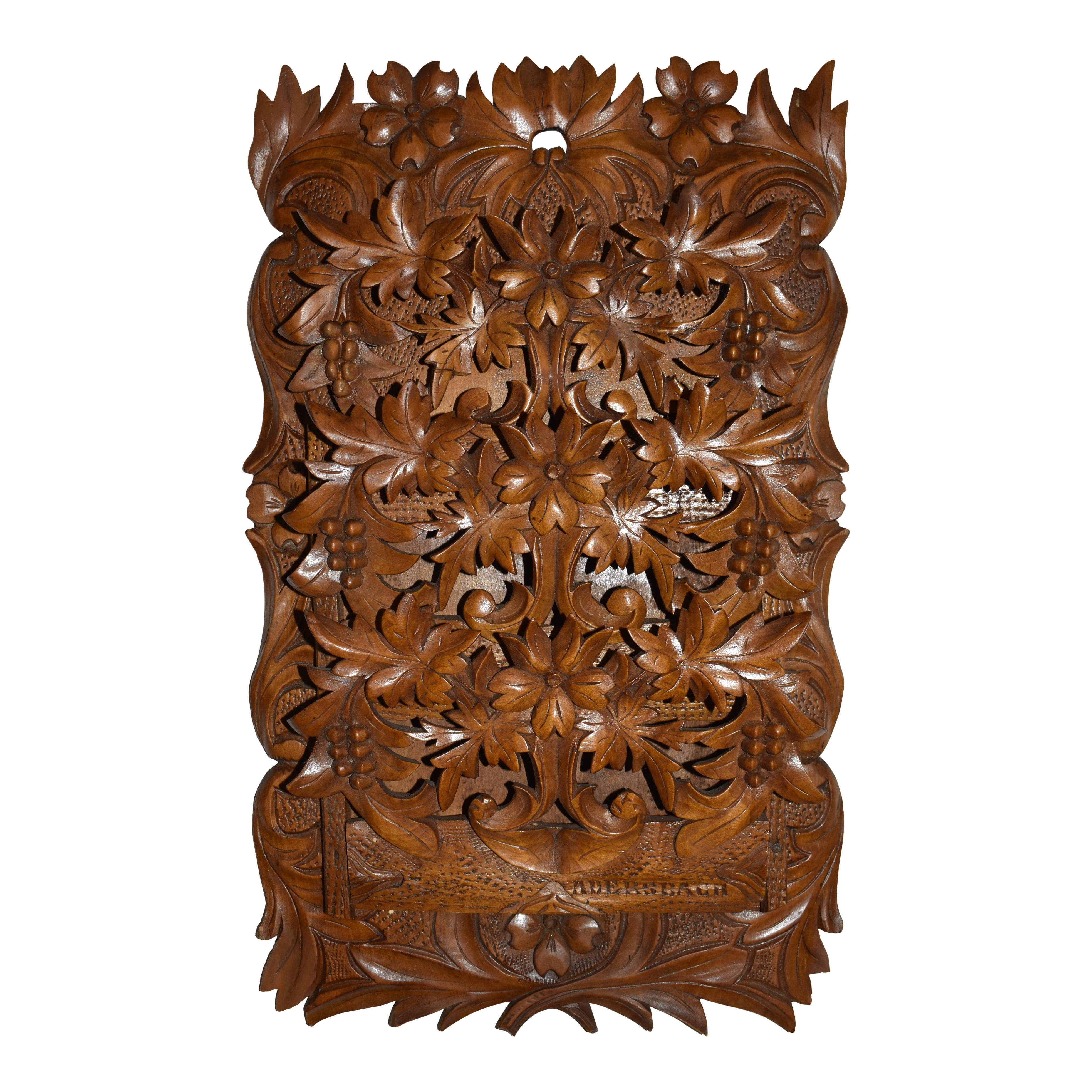 Dieser elegante, aus massivem Nussbaumholz geschnitzte Taschenhalter ist mit wunderschön geschnitzten Blumen, Blättern und Trauben verziert. Die drei Klapptaschen lassen sich öffnen, um Briefe oder kleine Dokumente aufzunehmen. In der linken unteren