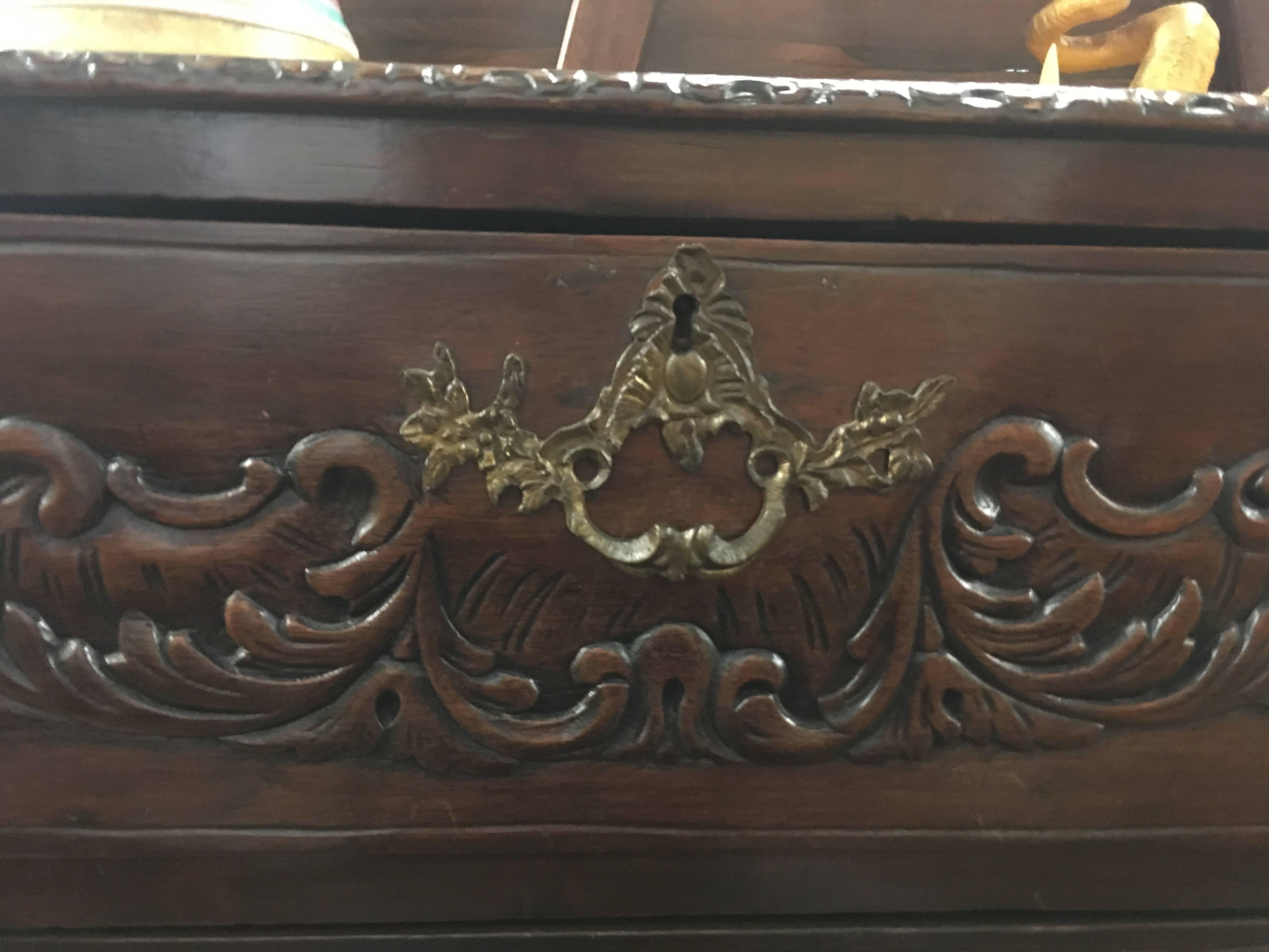 Intricately carved 19th century four-drawer lowboy or dressing table in the Queen Anne style, crafted from hardwood in a rich, deep walnut stain. The unique trapezoid-shaped top with a decoratively carved edge is 23