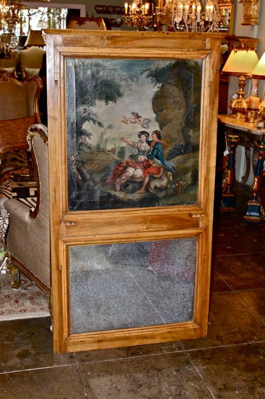  Cadre trumeau en noyer français avec peinture à l'huile d'un couple romantique et d'un chérubin dans une prairie avec des arbres et des fleurs tout au long de la scène. Le miroir est patiné à l'ancienne.