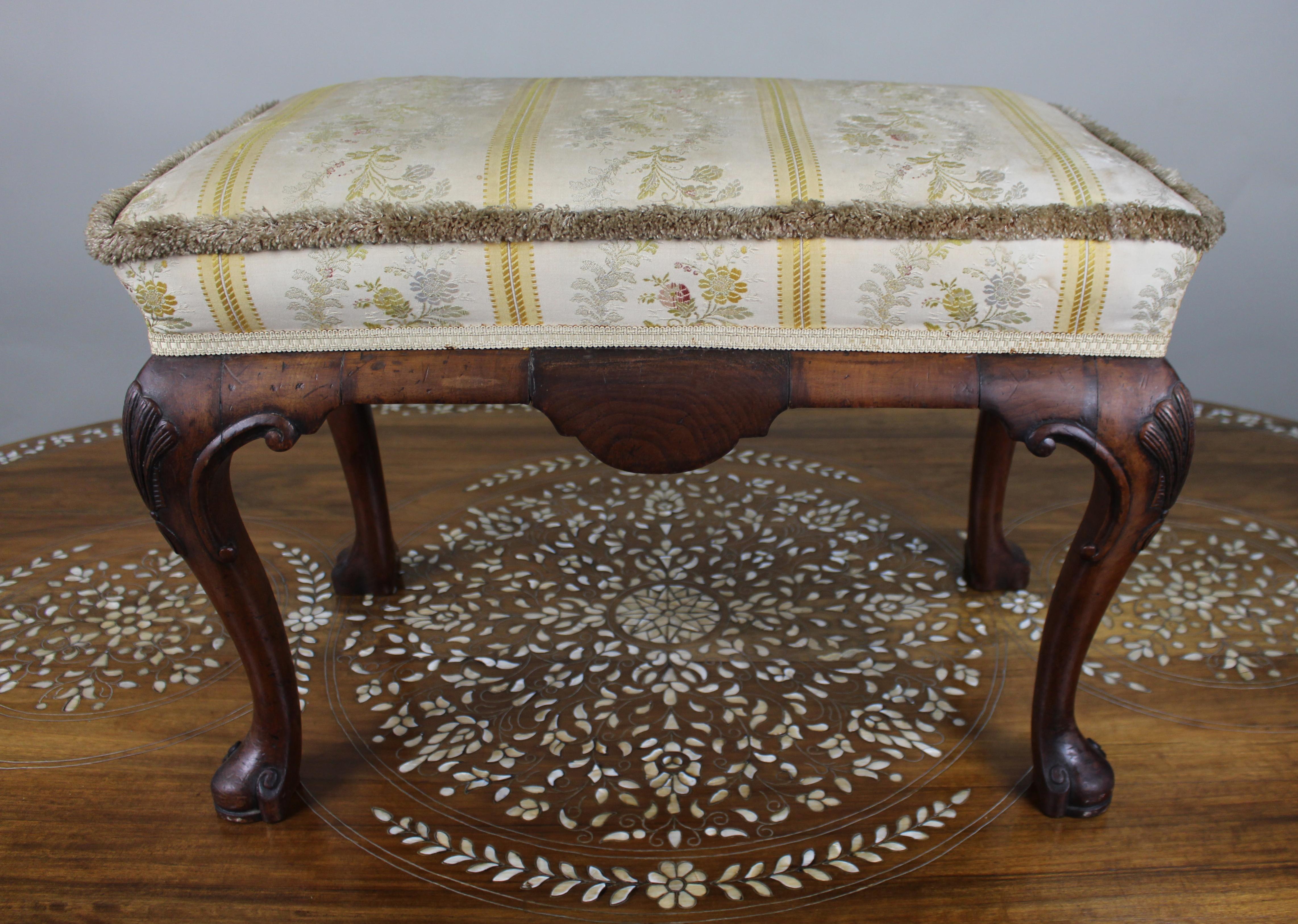Carved Walnut Upholstered Footstool c.1930

A well-made English walnut footstool dating from around 1930, in the Chippendale revival style. The frame is finely carved with shell motifs to the knees and scroll feet, displaying good quality