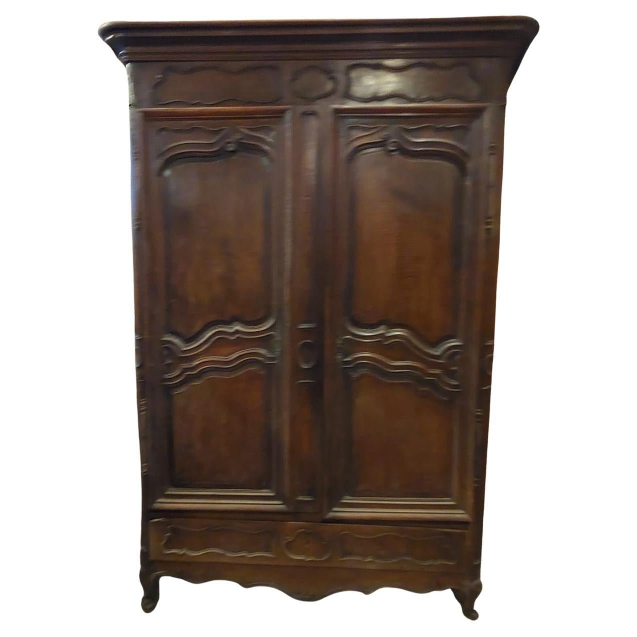 Antico armadio in noce massiccio, intagliato a mano con forme ondulate, completo di due ante e un cassetto, originale del XVIII secolo, proveniente dalla Francia.
Molto elegante e capiente, misure Maximum in cm L 145 (+ 10 cm circa di sporgenza del