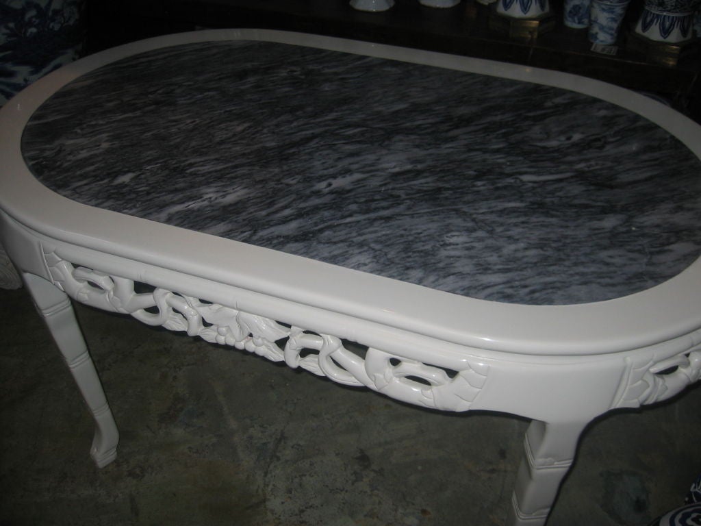 Ornately carved Chinese table with vines and leaf motif. Beautiful deep veining to the grey marble inset. Lacquer finish is new.