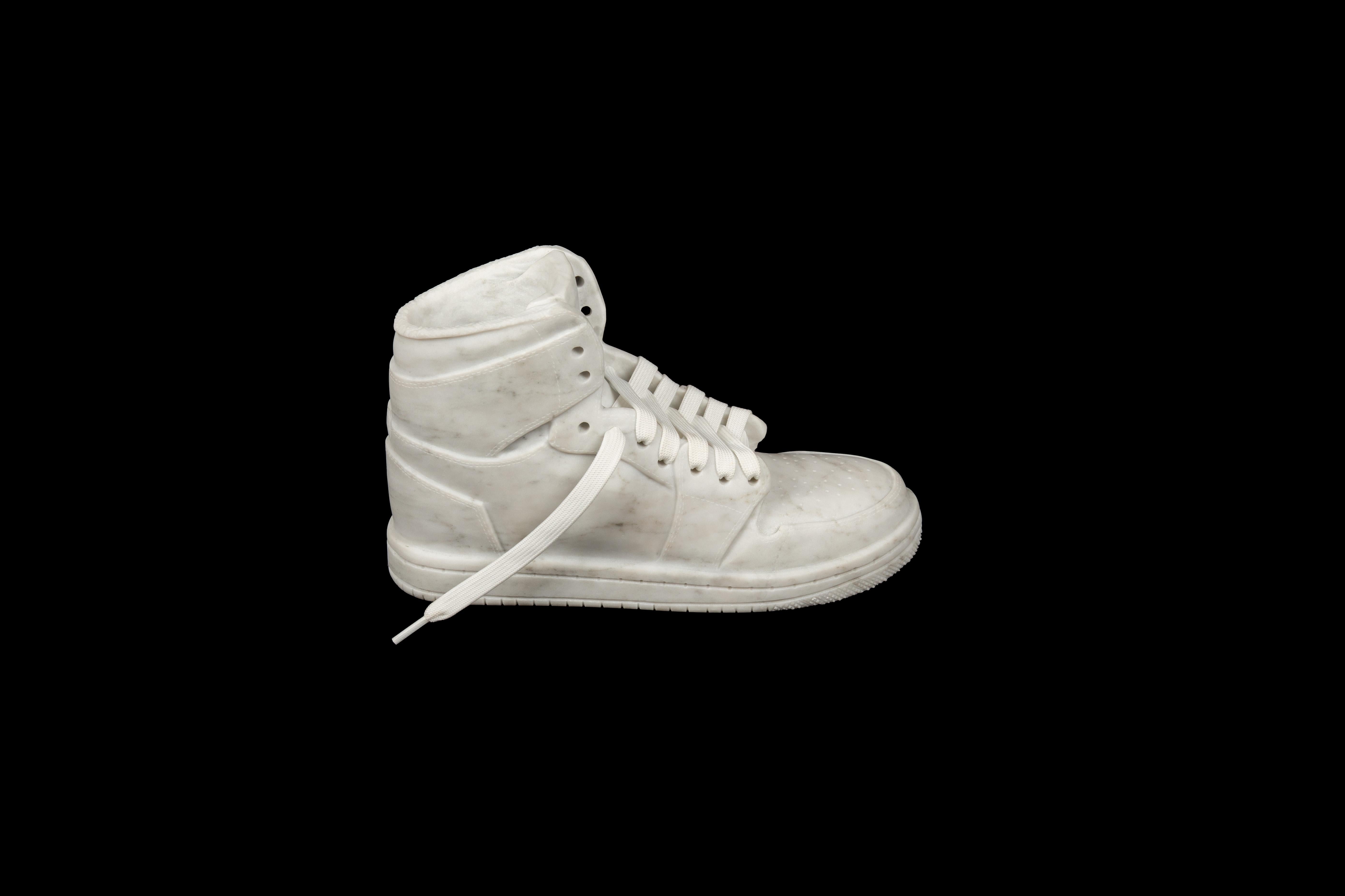 21st Century Carved White Marble Hightop Sneaker Sculpture: This sculpture serves as a captivating symbol of the enduring appeal and cultural significance of footwear, elevating the mundane to the realm of high art and inspiring contemplation on the