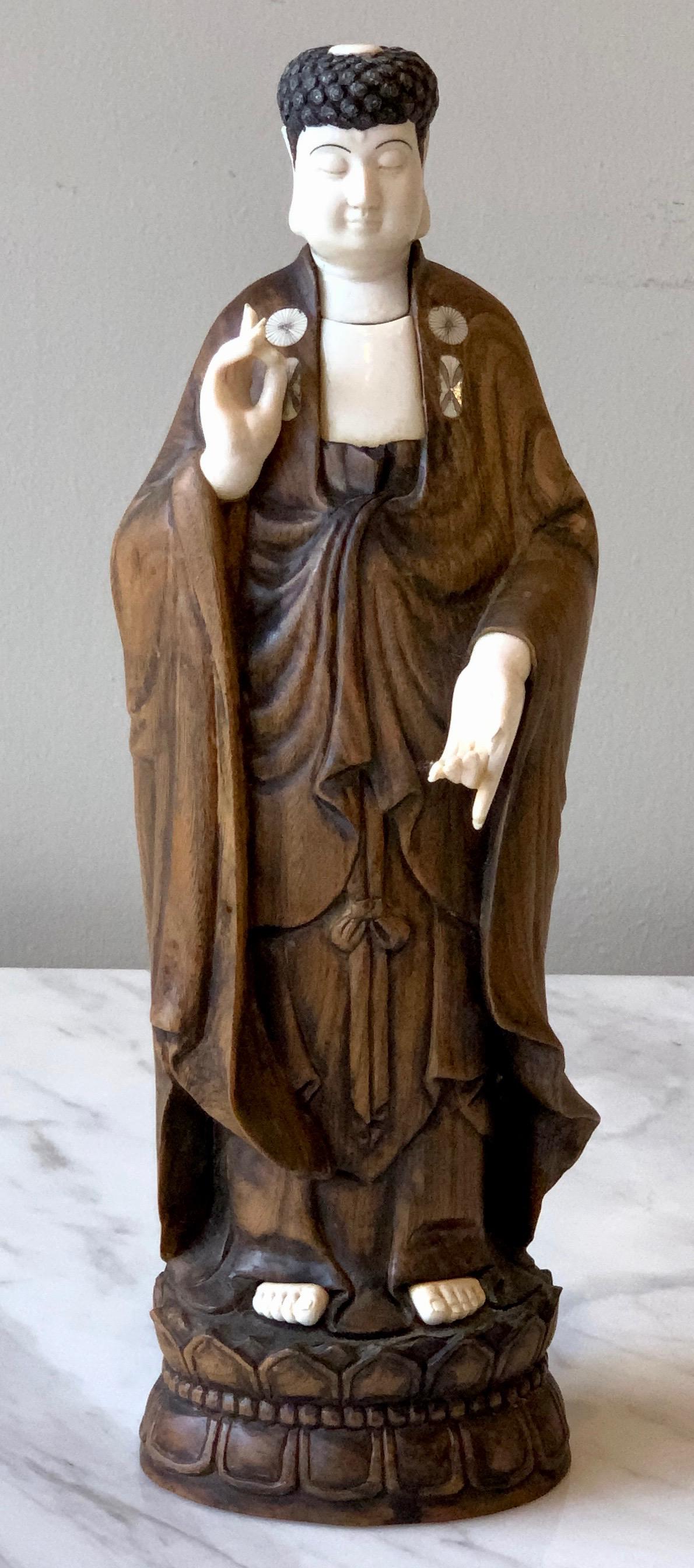 An elegant 19th century carved wood and bone statue of standing Buddha.