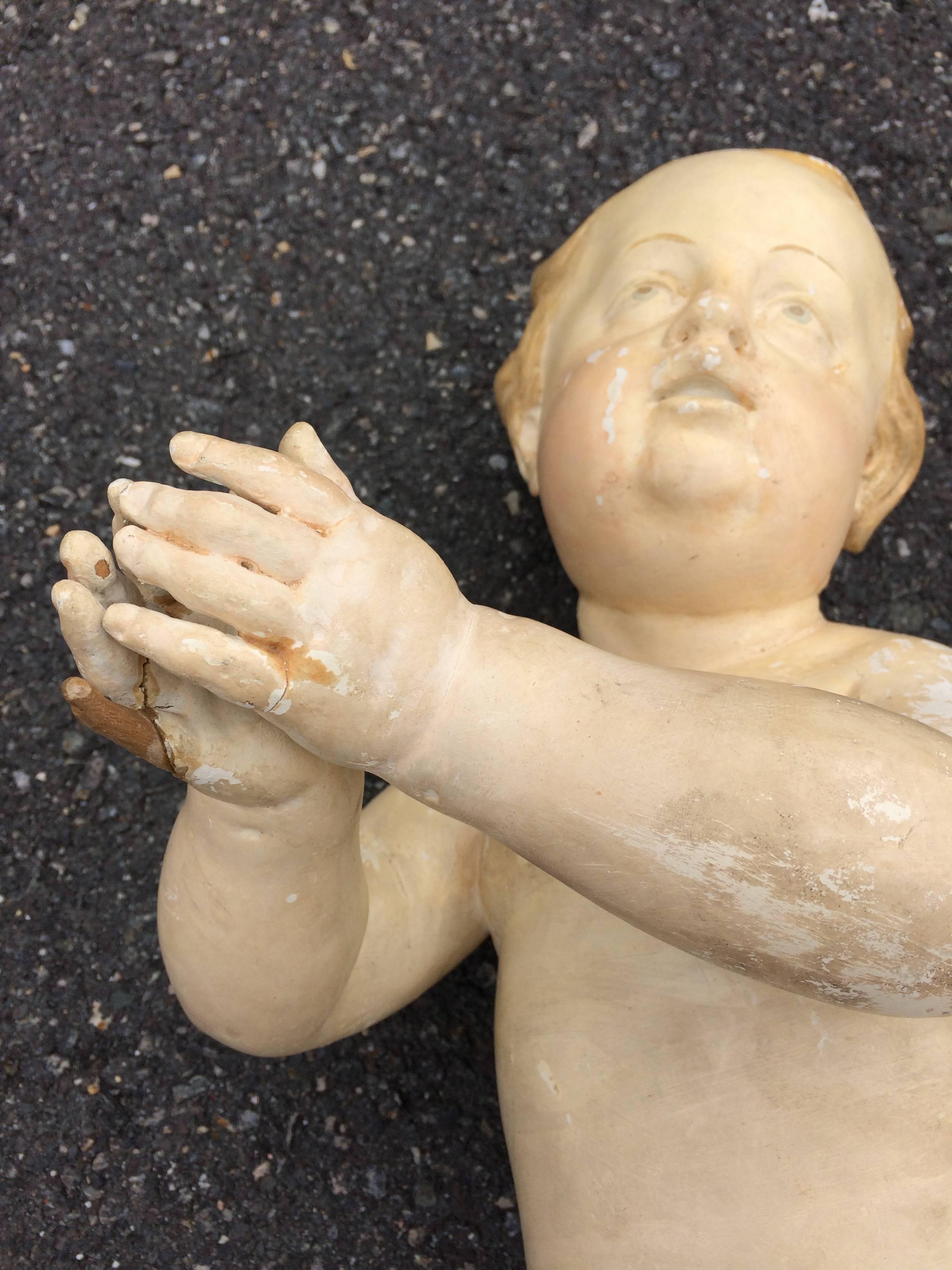 Beautiful life like carved wood and hand-painted plaster coated cherub, probably a religious artifact, origin unknown.