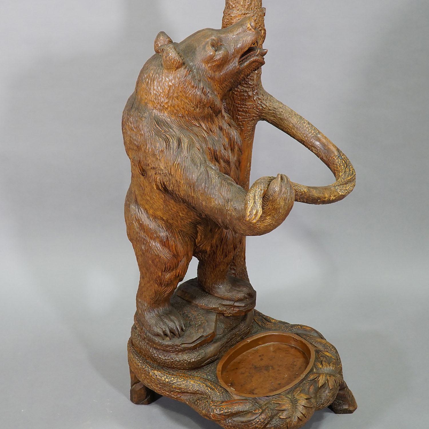 A hand carved wood bear hallstand. The mother bear looking upwards at her cub hanging in the branches. Executed, circa 1900, Swiss Brienz.

Measures: Width 19.69