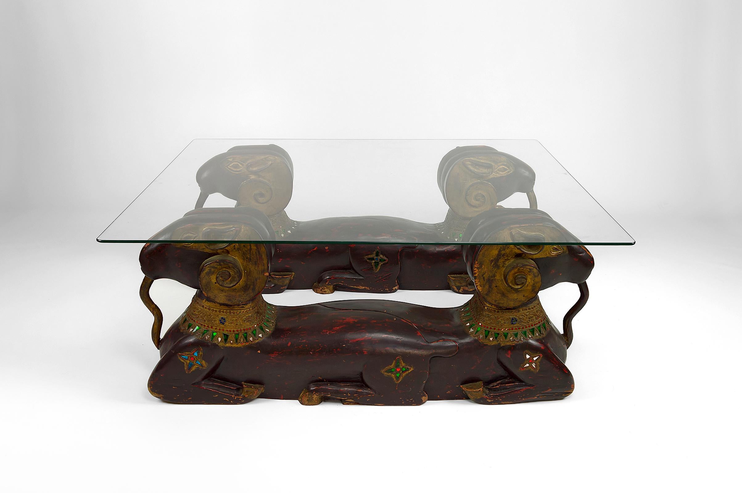 Superb coffee / side table composed of a glass plate and 4 goats / rams / aries in carved, patinated wood and decorated with colored glasses.

Hollywood Regency, circa 1970

In good condition, beautiful patina.

Dimensions of the glass plate: 100 x