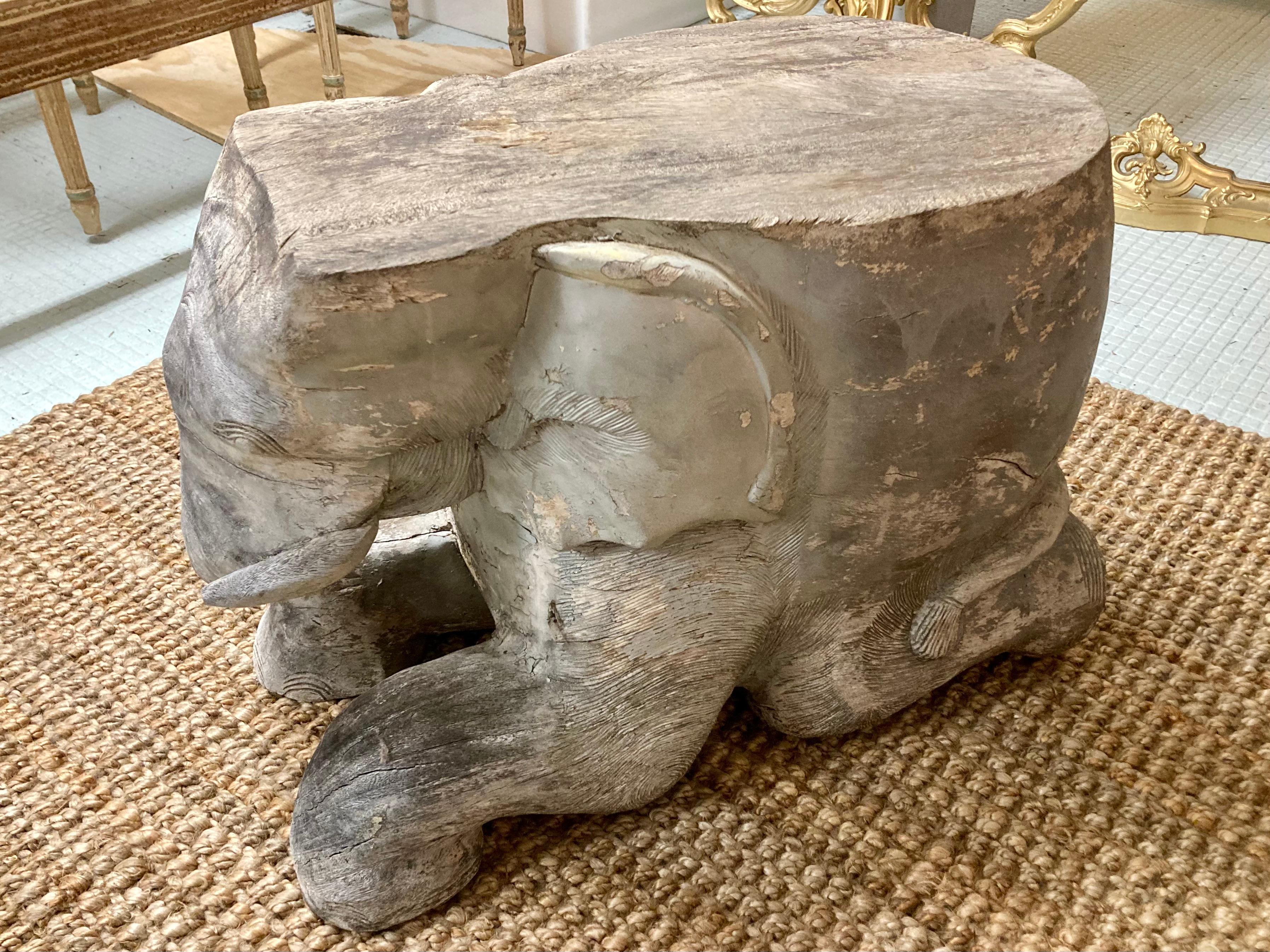 Beautiful carved wood elephant cocktail table/seat. This elephant shows trunk swinging to the left side, and we have two available in stock. Additionally, we have another pair with trunk swinging to the right so collect them all! They have an aged