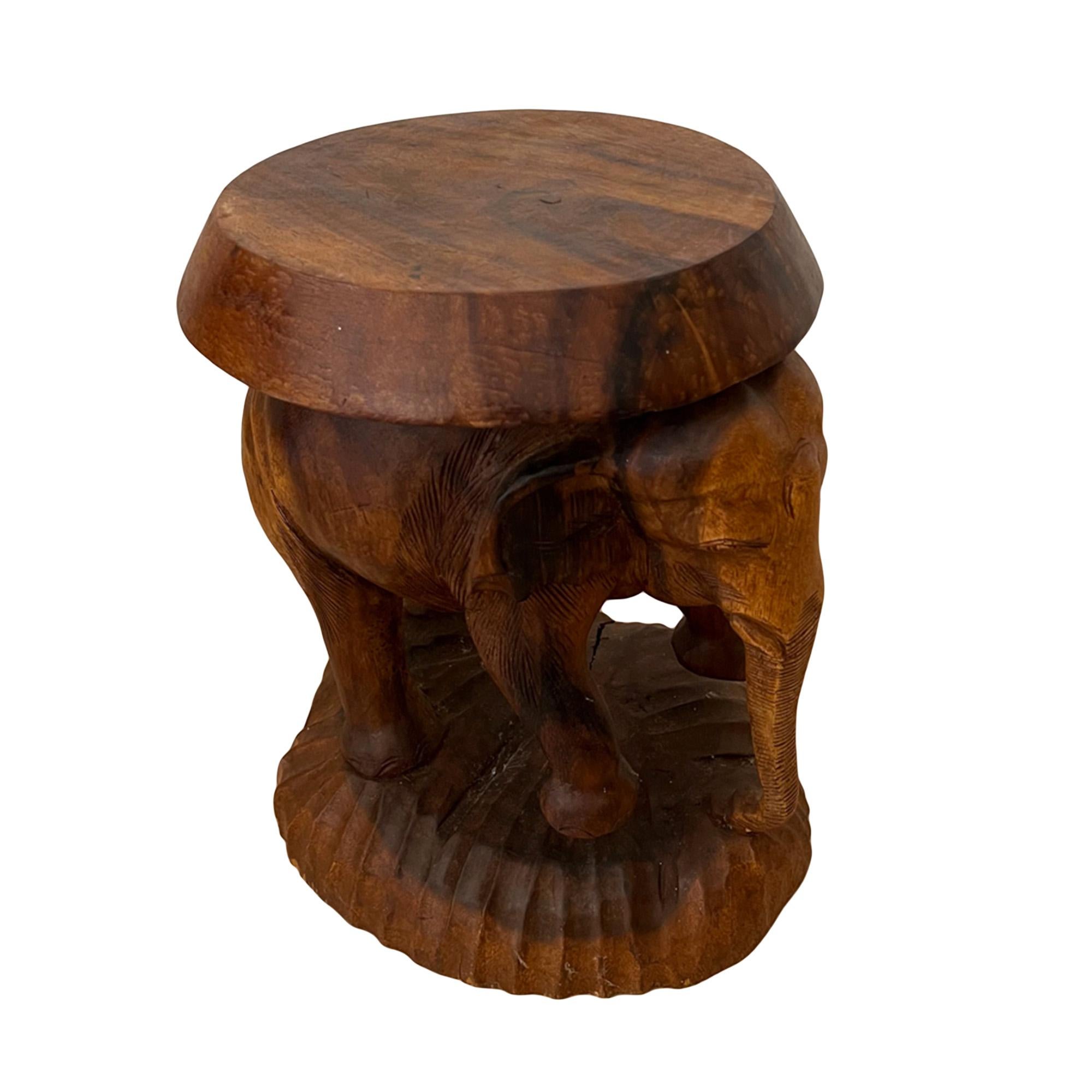 This quirky side table was carved from padauk wood in Ceylon in the 1950s. 

Please take a look at all the pictures to see the detail of the charming elephant - decorative and practical!

This elephant is standing on a carved wood base.