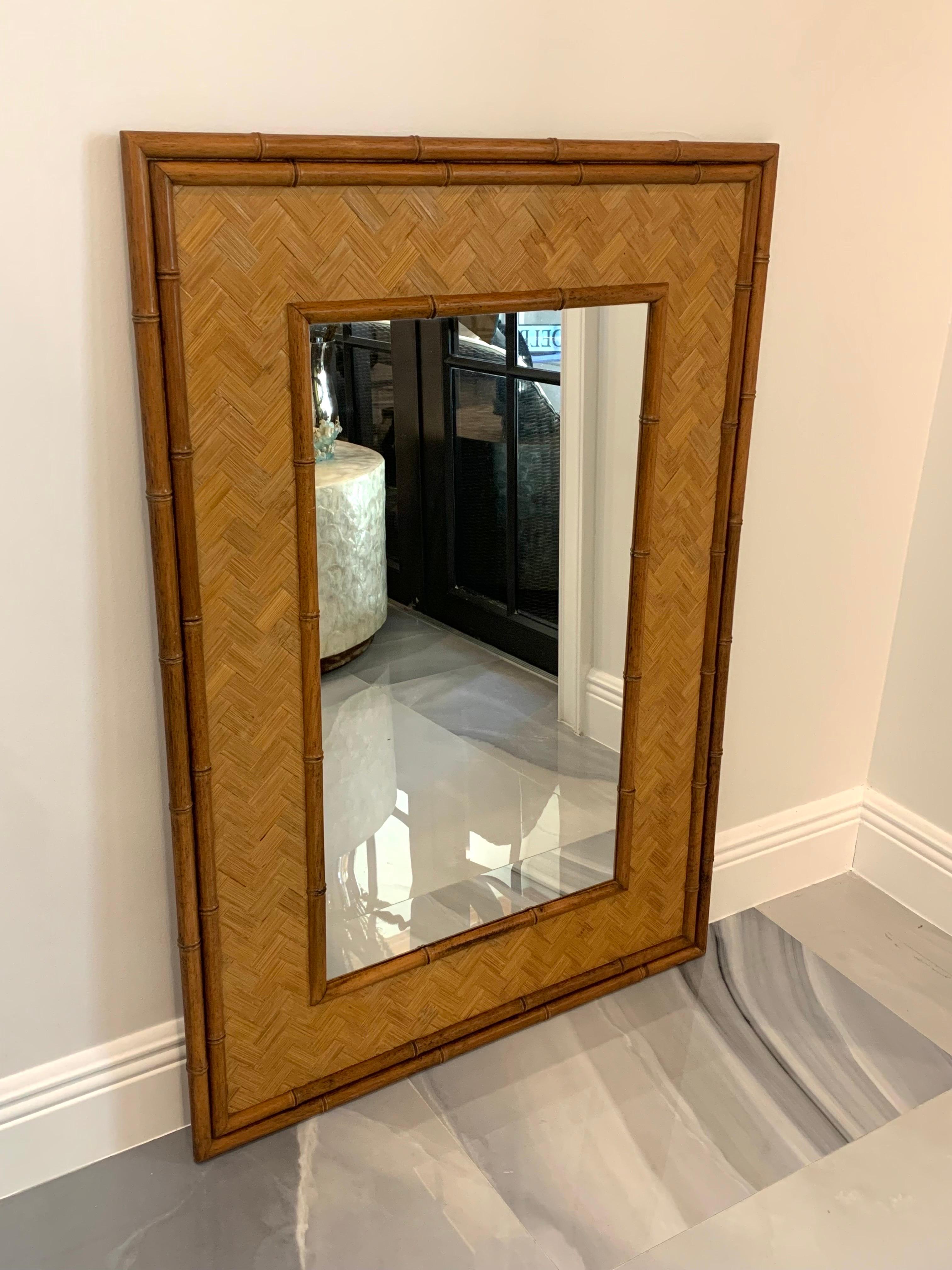 Regency mirror comprised of two wooden borders carved to mimic bamboo framing a rattan lattice pattern and the mirror. Well constructed and in good condition for its age. Has some beautiful light patina throughout and the mirror is in great shape.