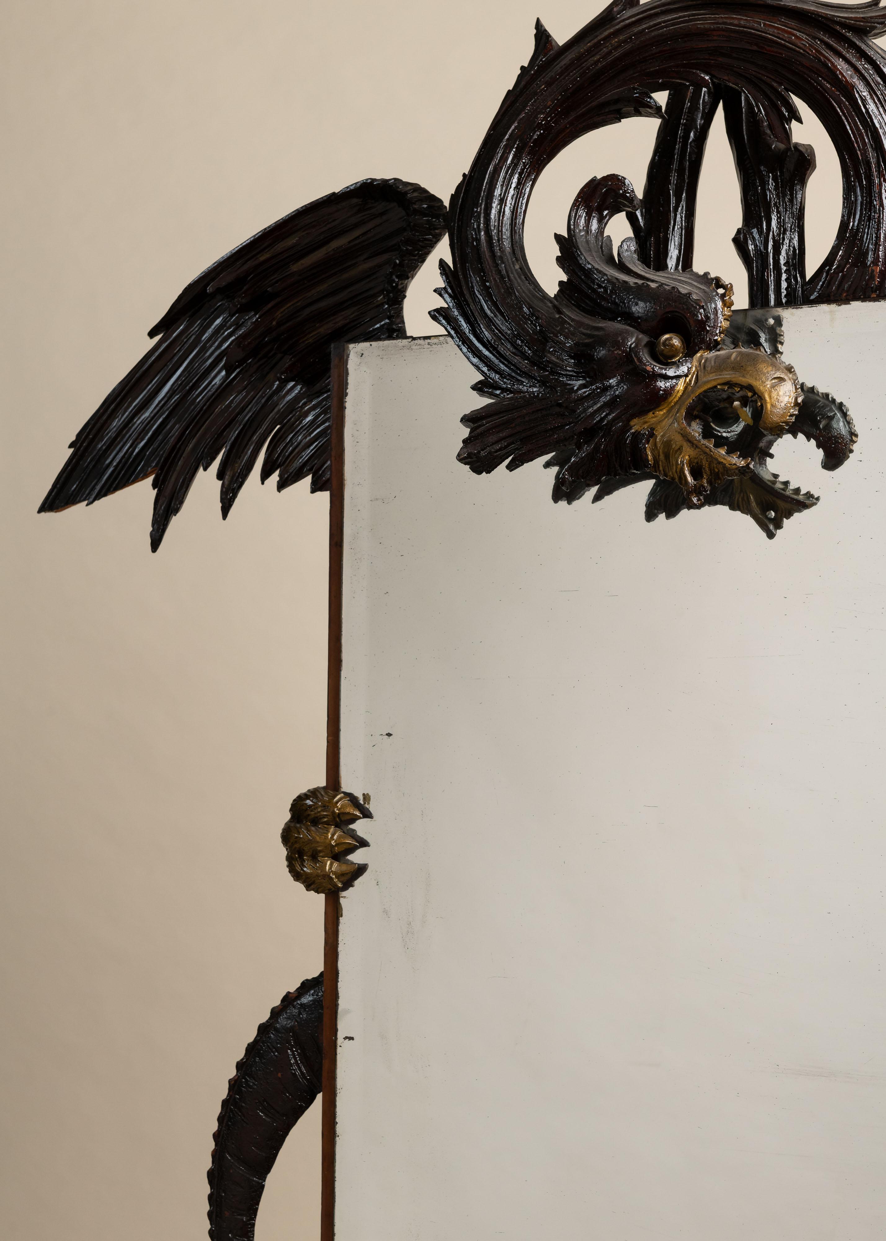 Antique Carved Dragon Mirror, Late 19th Century. An extraordinary rectangular mirror wrapped in the coils of a carved wooden dragon. The creature’s head projects from the top corner, its beak open and mane sweeping back in bold relief. Traces of