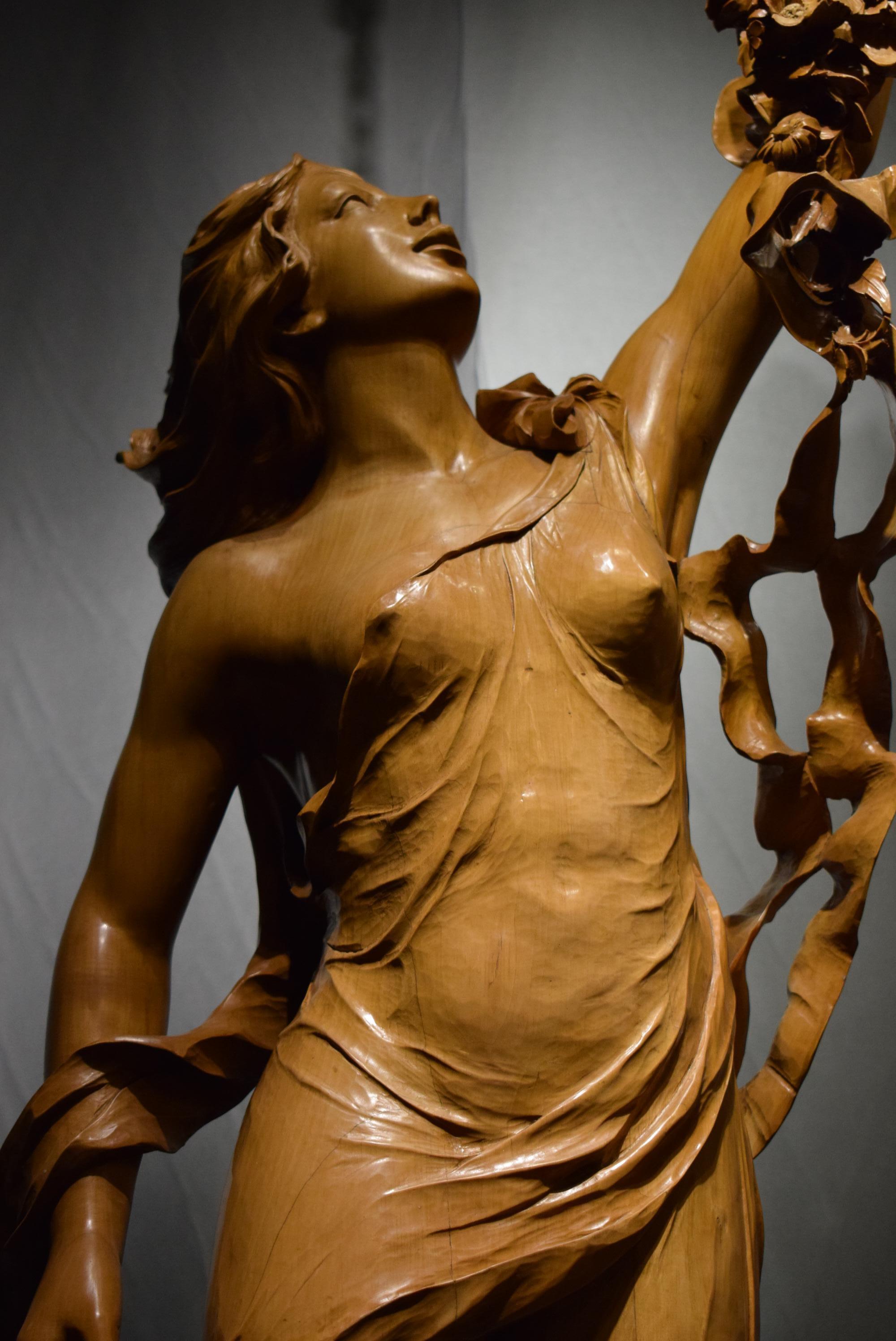 Magnificent limewood sculpture of a maiden dressed in classical garments, holding a clock. Extraordinary carving. The detail of hair, garment, and ribbons in the wood are the work of a master carver.
Height (Overall) 93