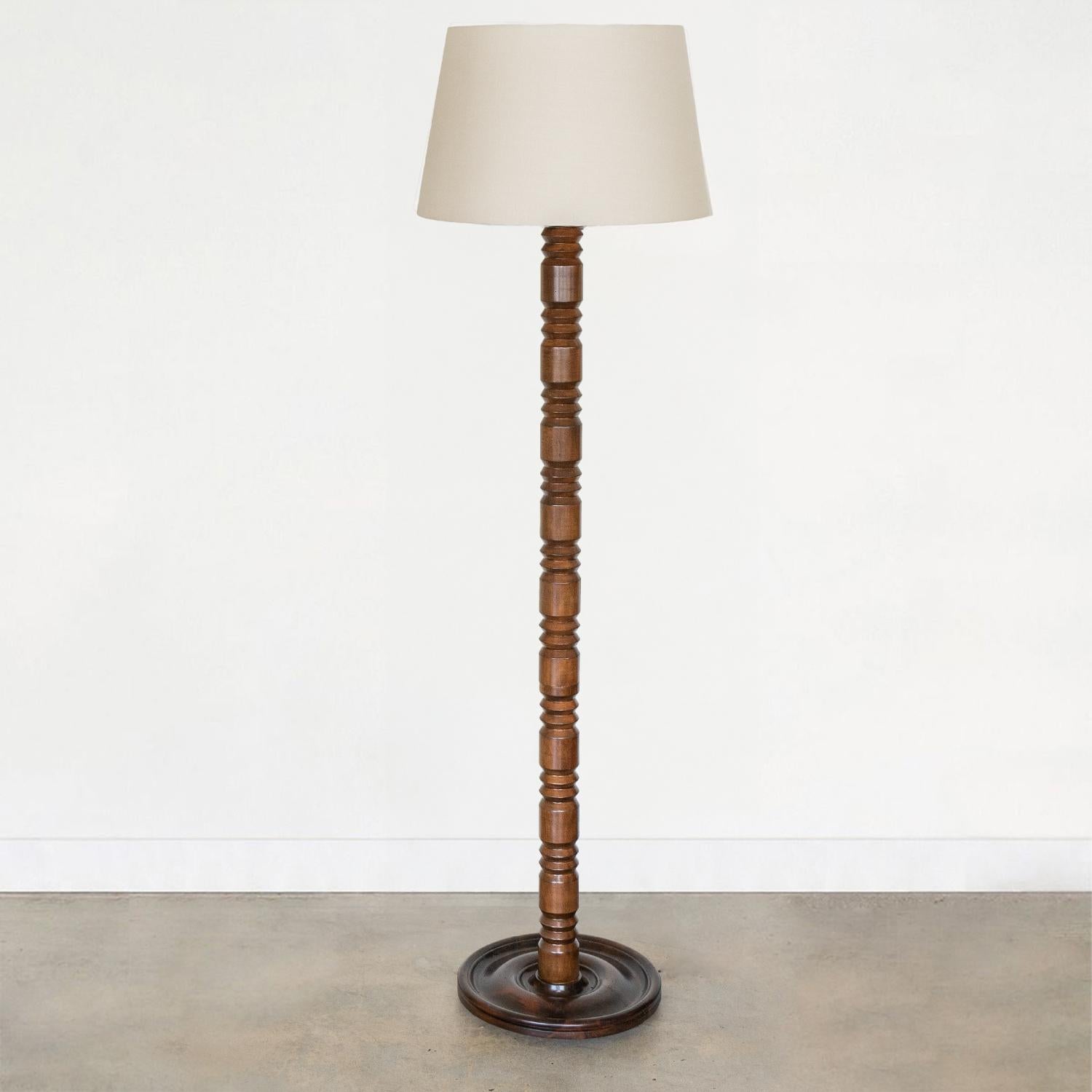 Lovely carved wood floor lamp by Charles Dudouyt from France, 1940s. Great carved design on stem with newly refinished dark stain on wood. Newly re-wired and new linen shade. Vintage wood shows pinholes throughout and repaired crack on base.