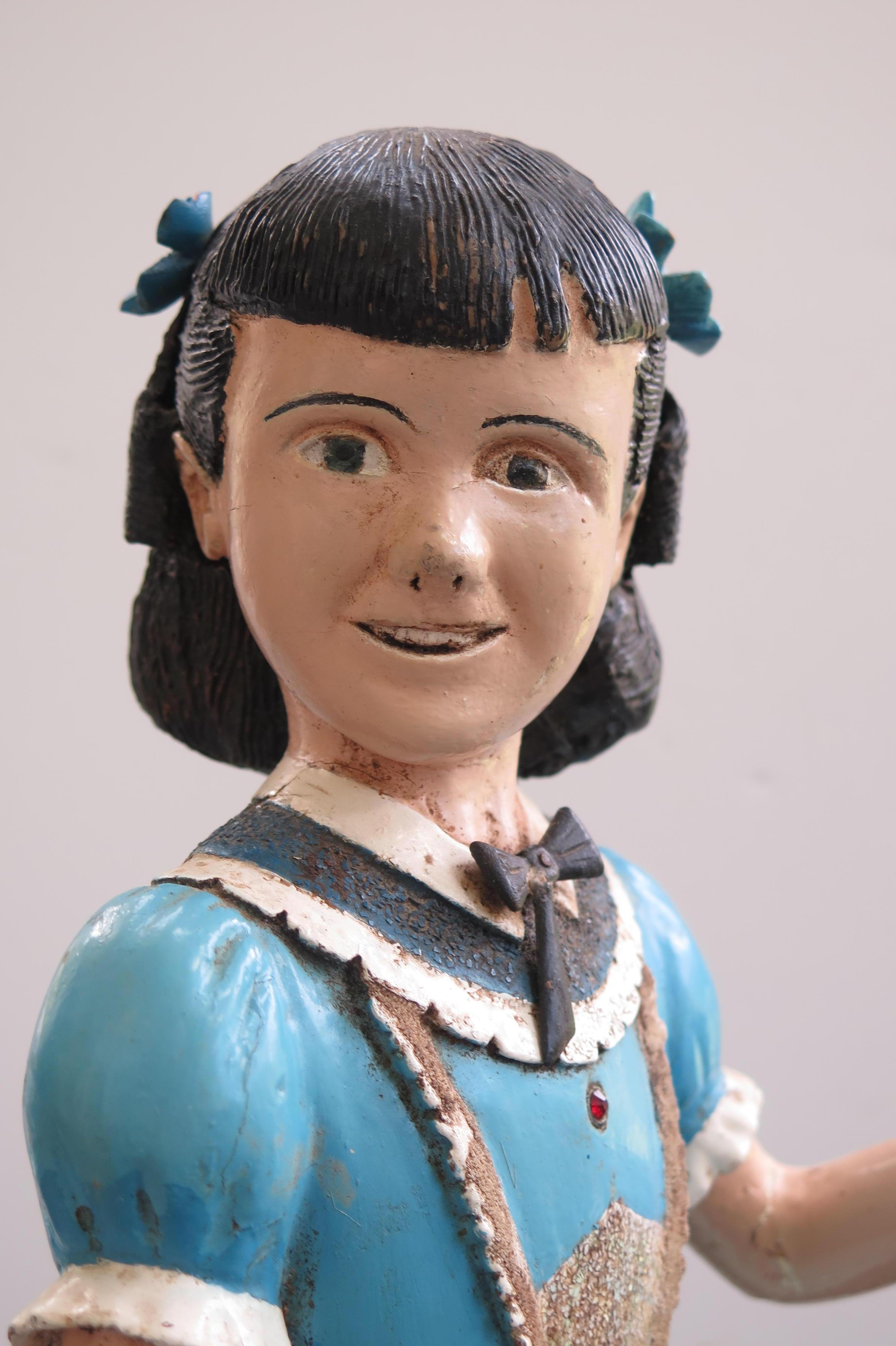 Harold Ibach and his wife were not able to have children but Harold could carve so he made an imaginary daughter he called Kitty. Kitty was carved and pieced of wood and meticulously painted. The turned head animated the girl and he added bows to