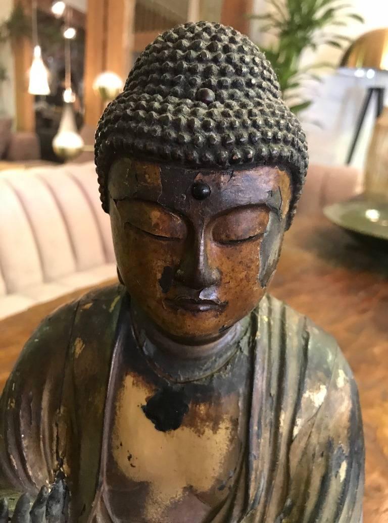 This truly a magnificent piece. Stunning. Beautiful. Supremely serene.

Meticulously hand carved in such fine and amazing detail (see hands and flowing robes). Gilded throughout. Seated with narrowed eyes in deep meditation and hands in Buddhist