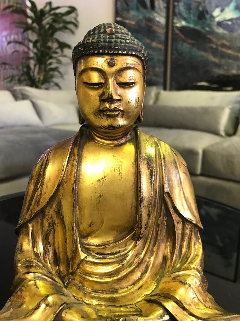 This truly beautiful and serene piece. 

Meticulously hand carved in fine detail. Gilded throughout. Seated in deep meditation with folded hands and flowing robes. 

We are listing as early 20th century but we feel it could easily be older,